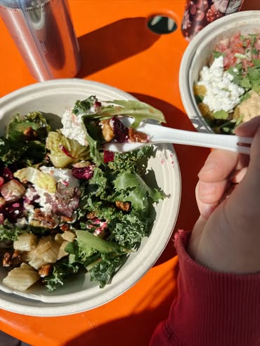 Guest eating a Forage Kitchen Local Roots grain bowl at an orange table.