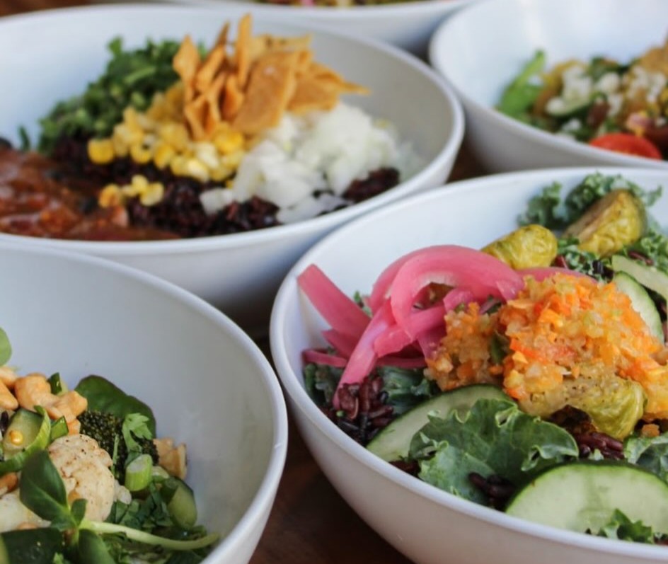  Assorted colorful grain bowls from Forage Kitchen with whole grains, vegetables, and toppings.