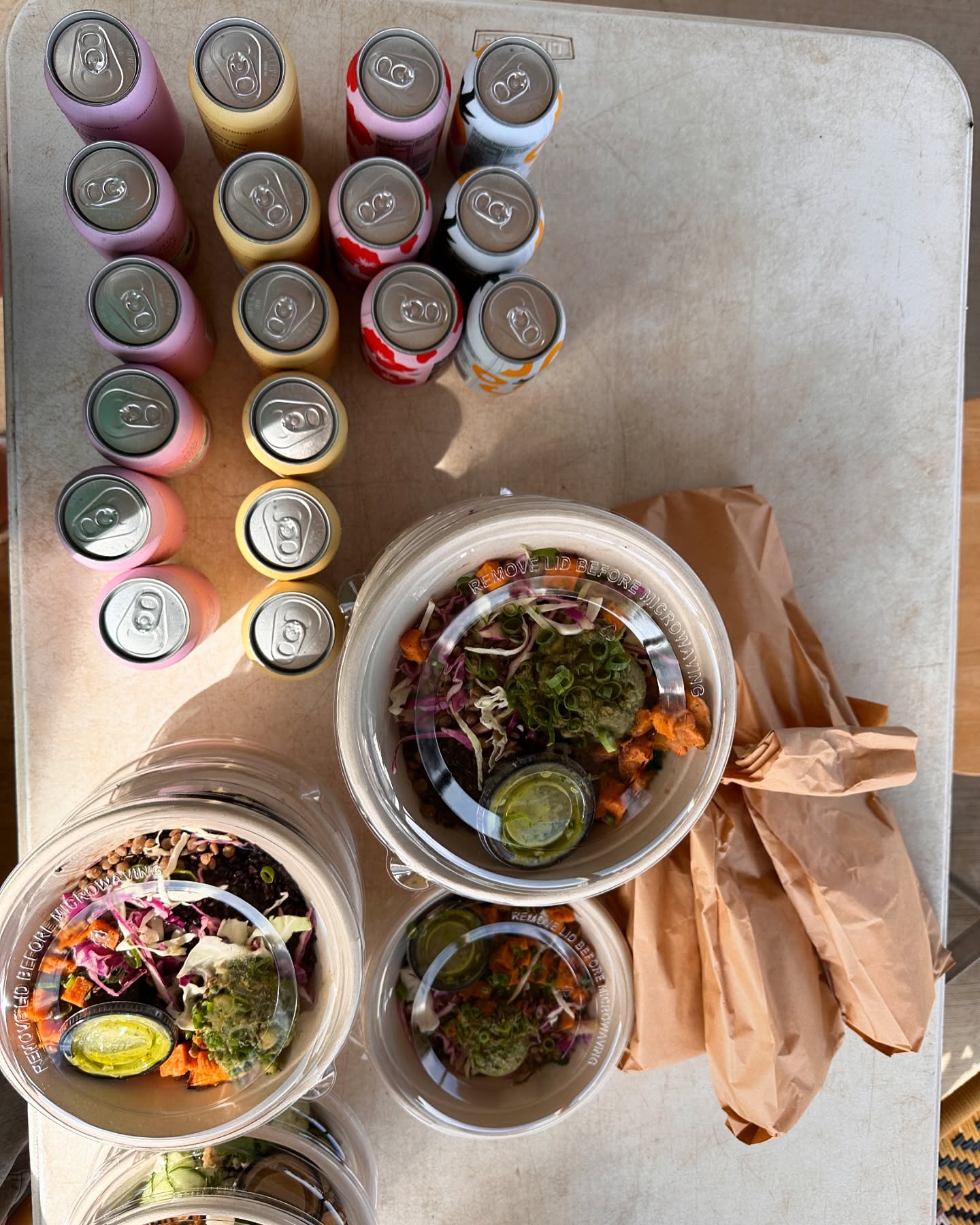 Kombucha, tepache, wraps, and grain bowls, catered by Forage Kitchen, are on a table.