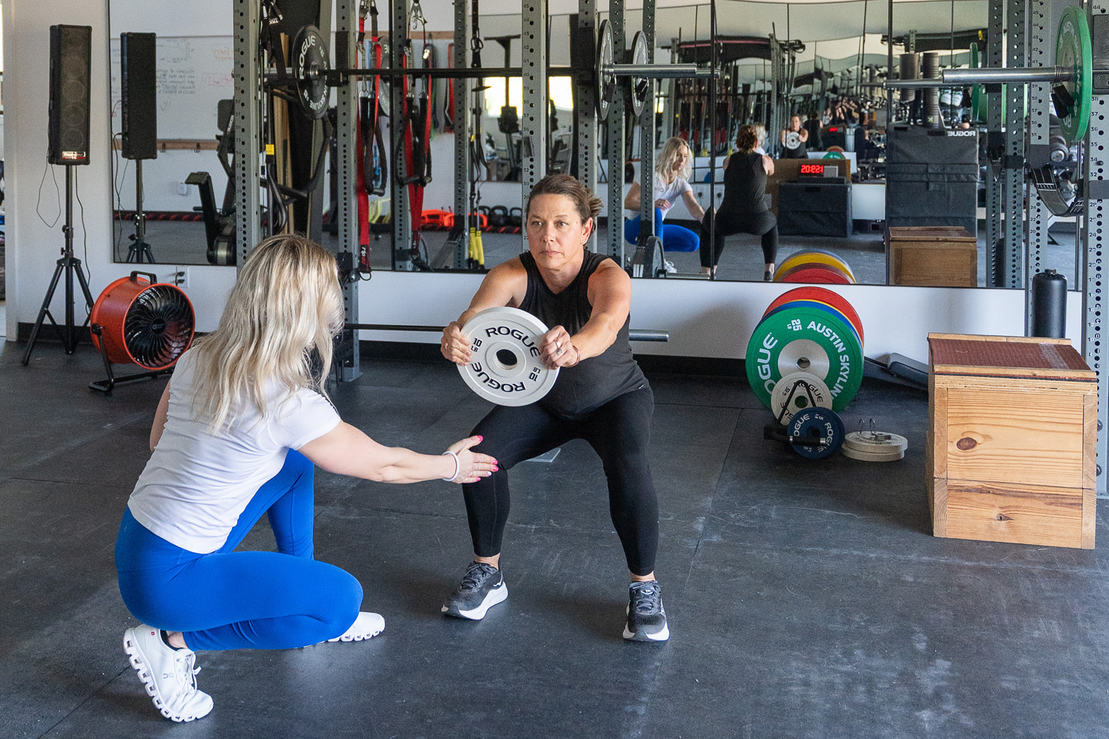 Dr. Shania Grode is training a woman in the gym as part of her wellness and performance-focused lifestyle.