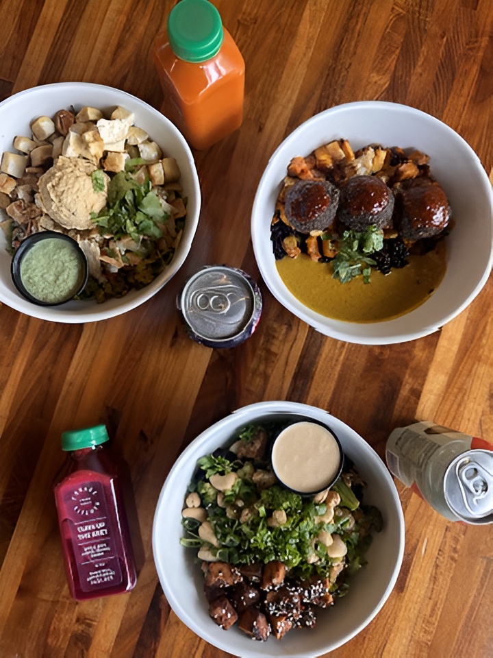 Three plant-based bowls: Thai Bowl, Cashew Bowl, and Club Med Bowl with fresh juice bottles and kombucha cans.