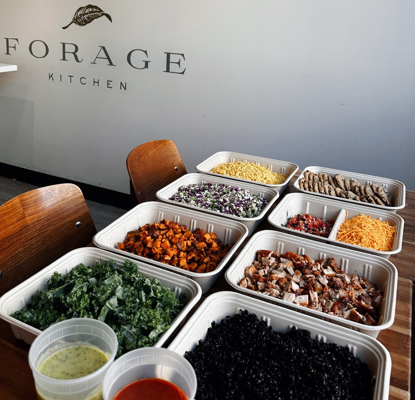 Fresh ingredients like kale, sweet potatoes, black rice, cabbage, cheddar cheese, and cookies at Forage Kitchen.