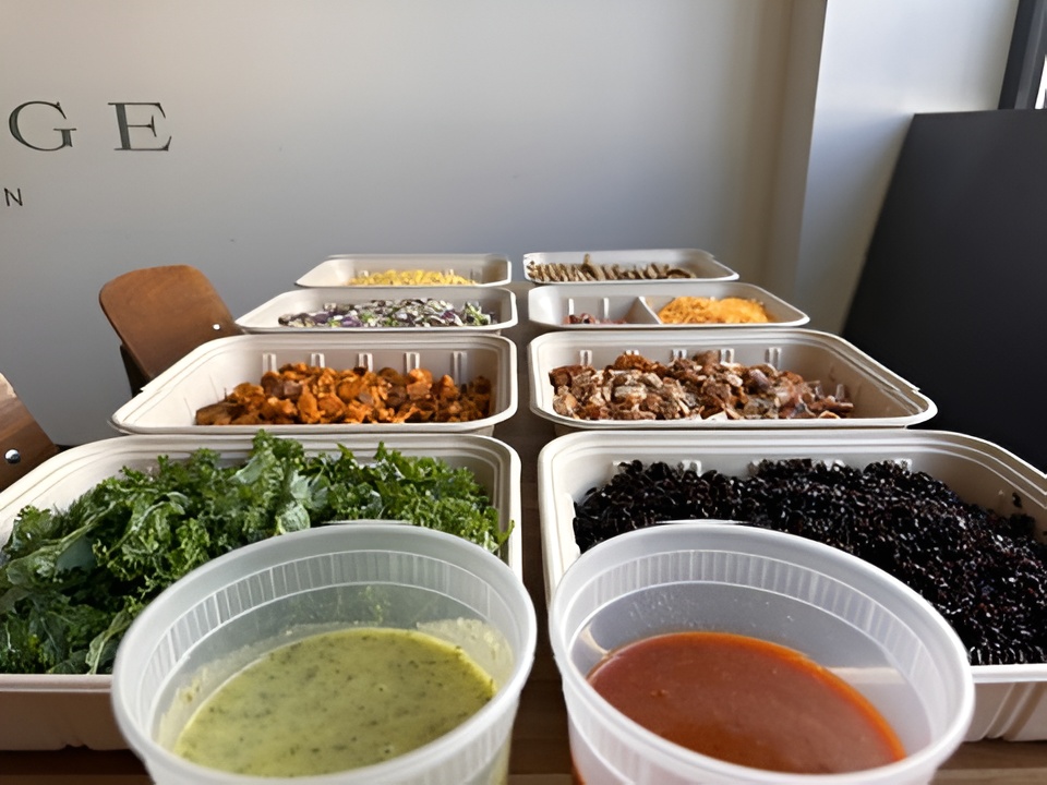 Various catering trays with kale, sweet potatoes, cabbage slaw, black rice, chicken, salsa, and cheese by Forage Kitchen.