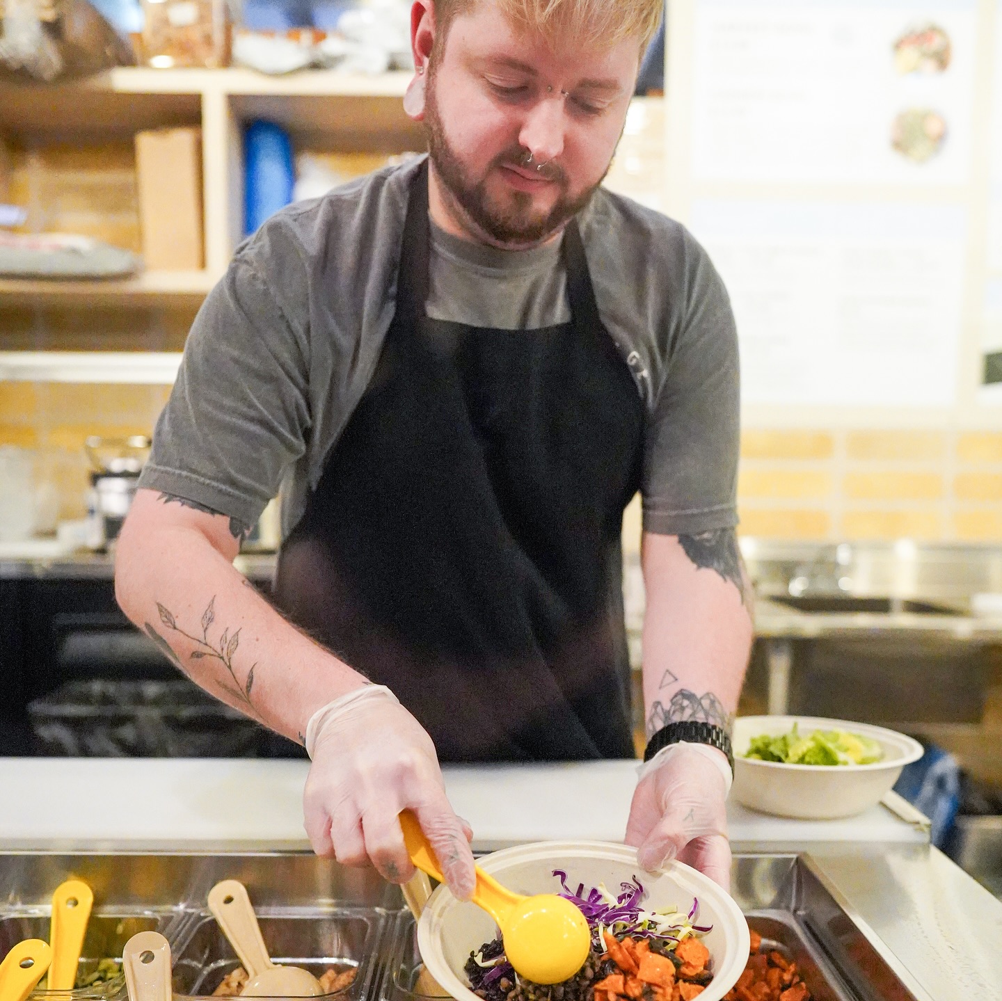 A chef at Forage Kitchen in Milwaukee is building a Power Bowl at the Build-Your-Own station.