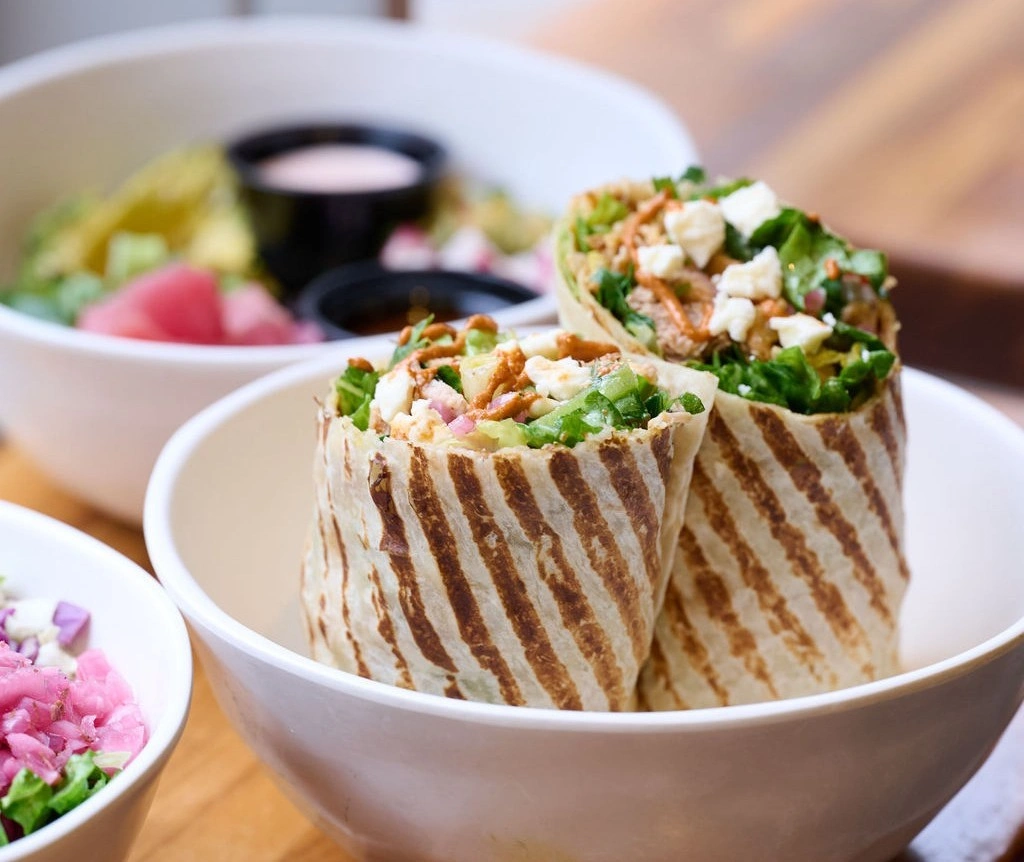 Two sliced, toasted wraps with visible grill marks standing in a bowl at Forage Kitchen.