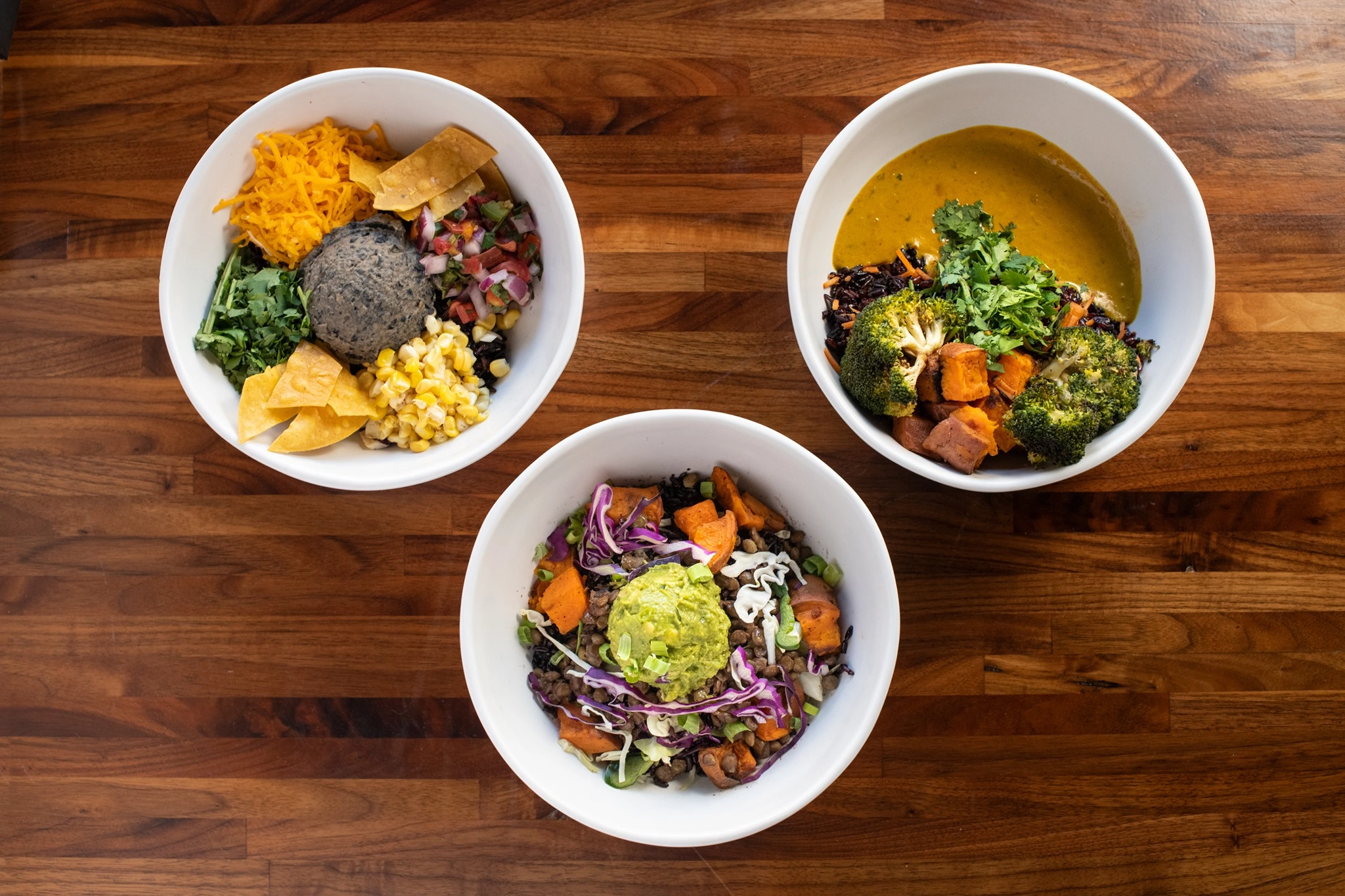 An overhead view of Fiesta, Power, and Thai plant-based grain bowls at Forage Kitchen.