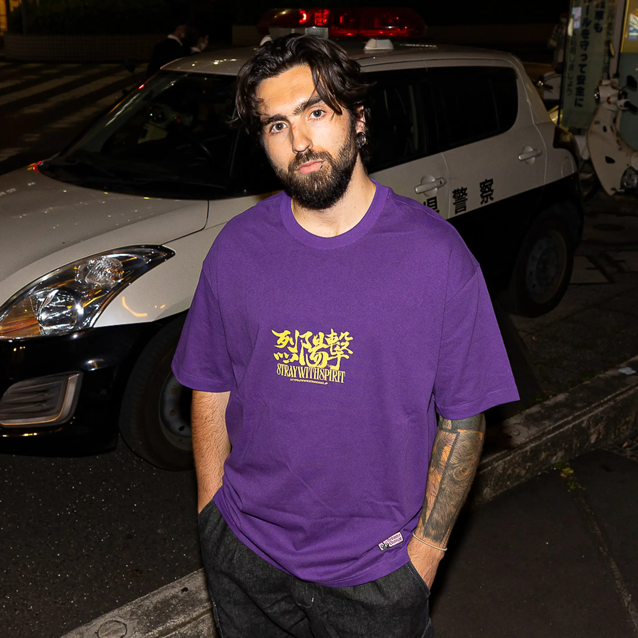 Campaign image of a skater wearing the bright purple strike tee on the streets of Chiba. The front design, perfectly meshes english and Japanese kanji together for an loud but tasteful print.
