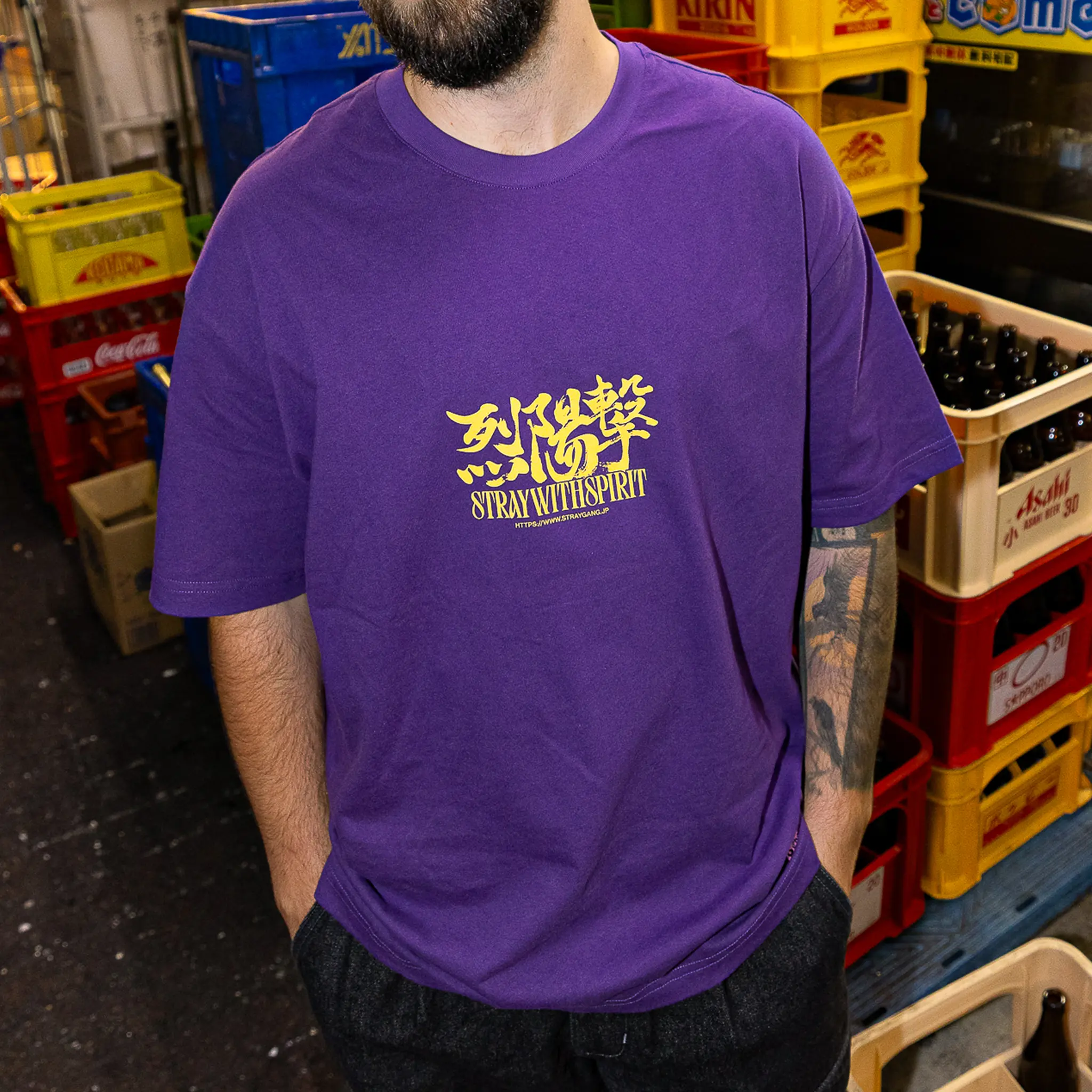 Image that shows a closer look of the strike tee's print, worn amidst the back-alleys of Tokyo by a skateboarder. 