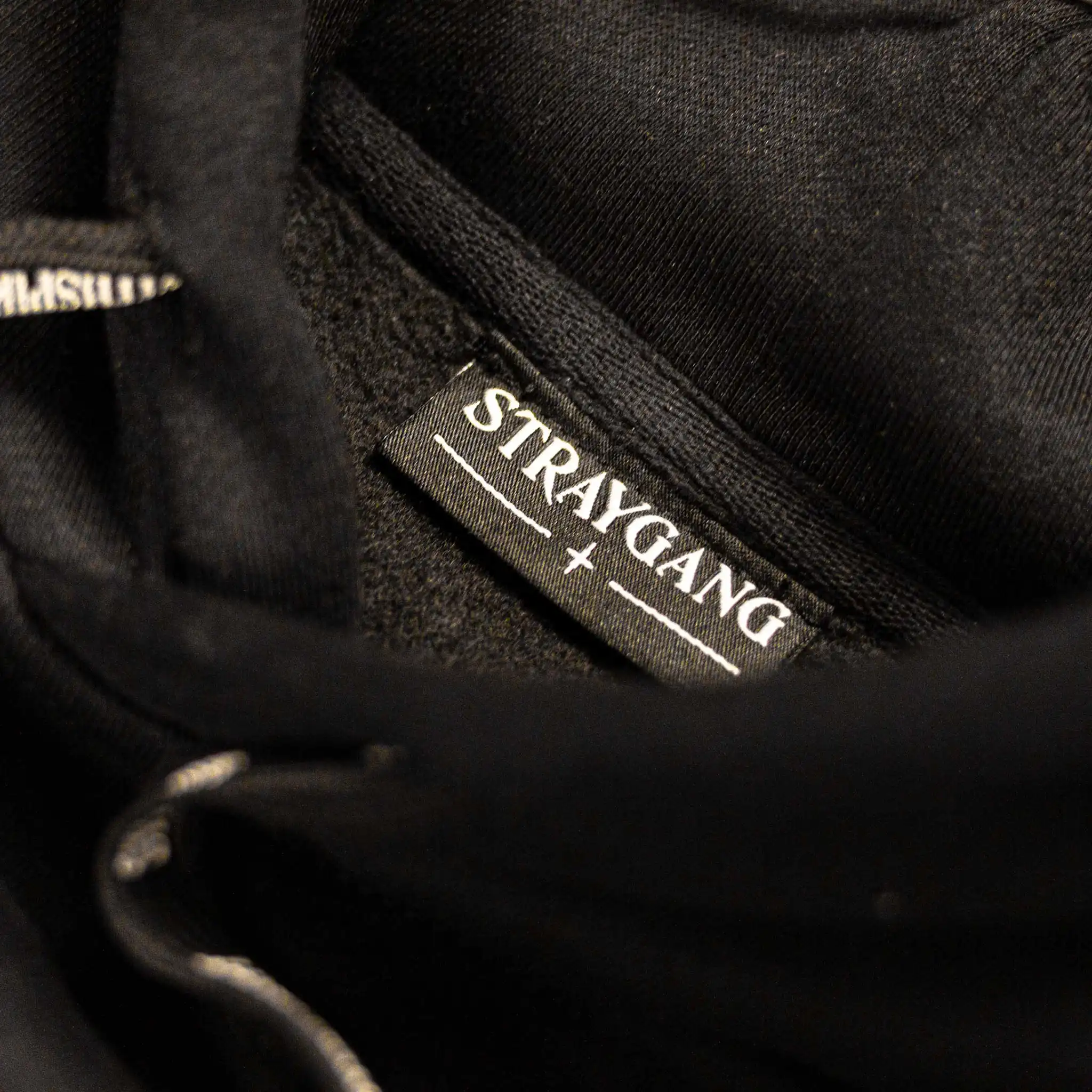 Straygang Spirit Hoodie in black, neck label detail with woven Straygang branding.