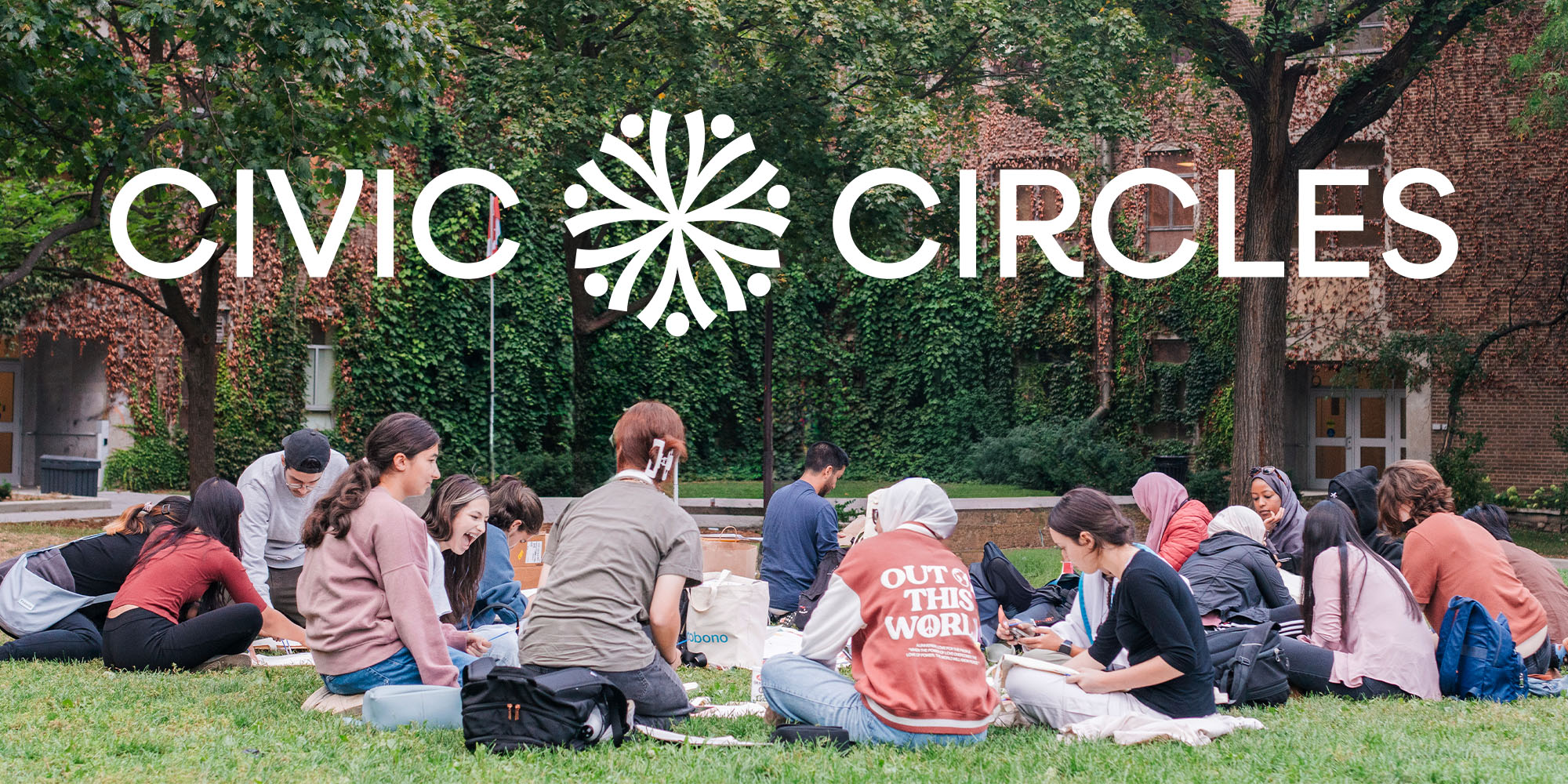 A group of youth and young adults sitting on green grass in a park with the Civic Circles logotype above them. 