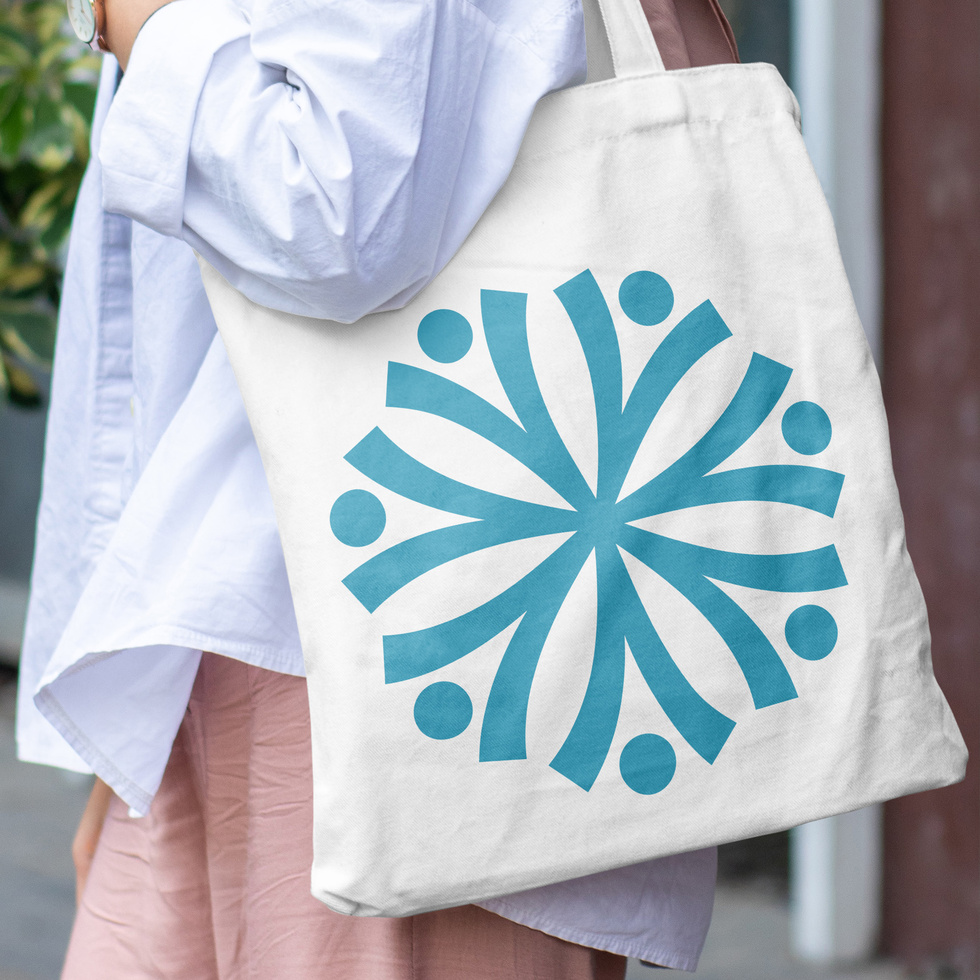 A tote design mockup where a young lady in a white shirt is holding a bag. 