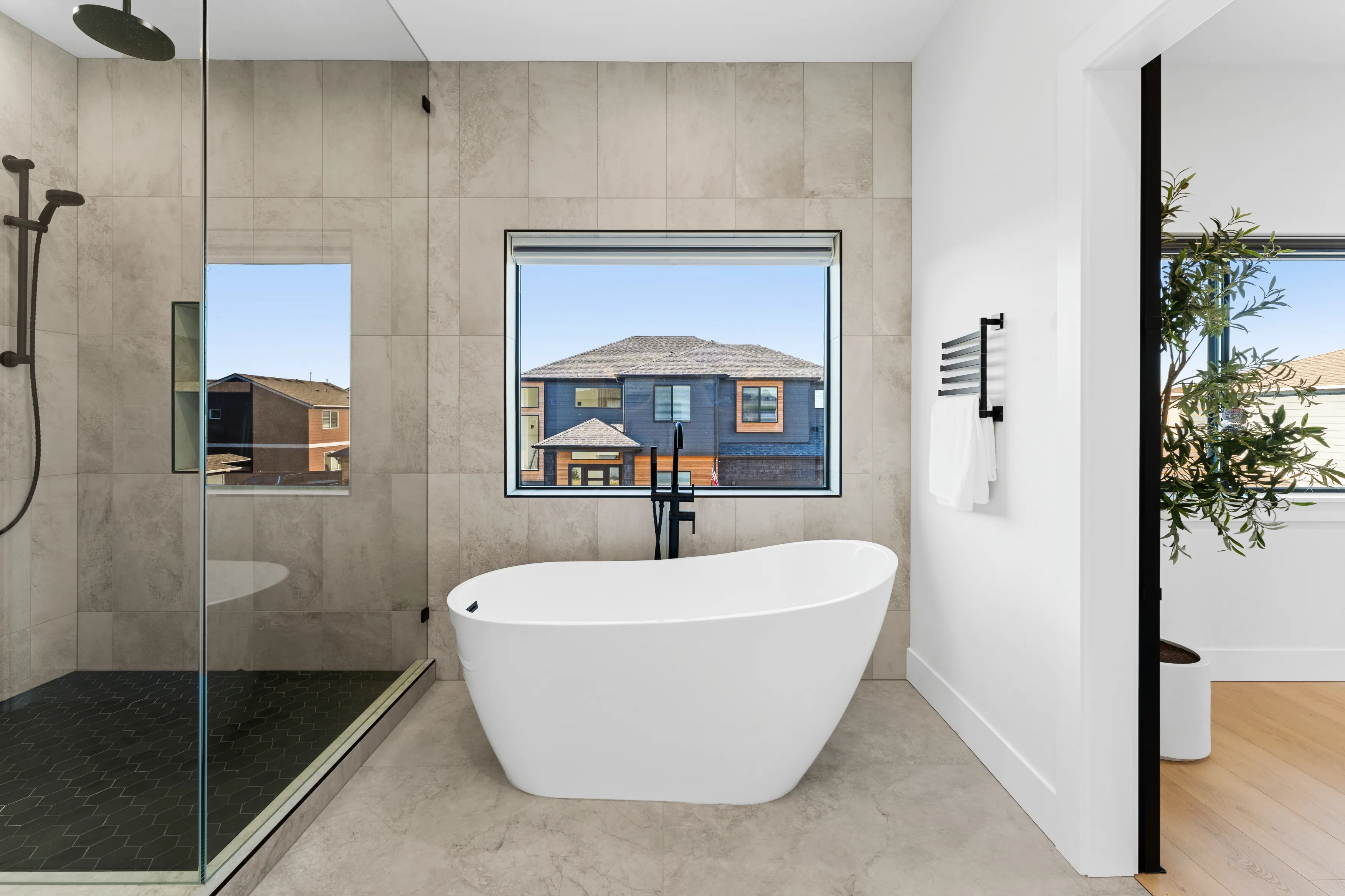 High-end custom kitchen in Issaquah showcasing black cabinetry, wood accents, large island, and minimalist design.