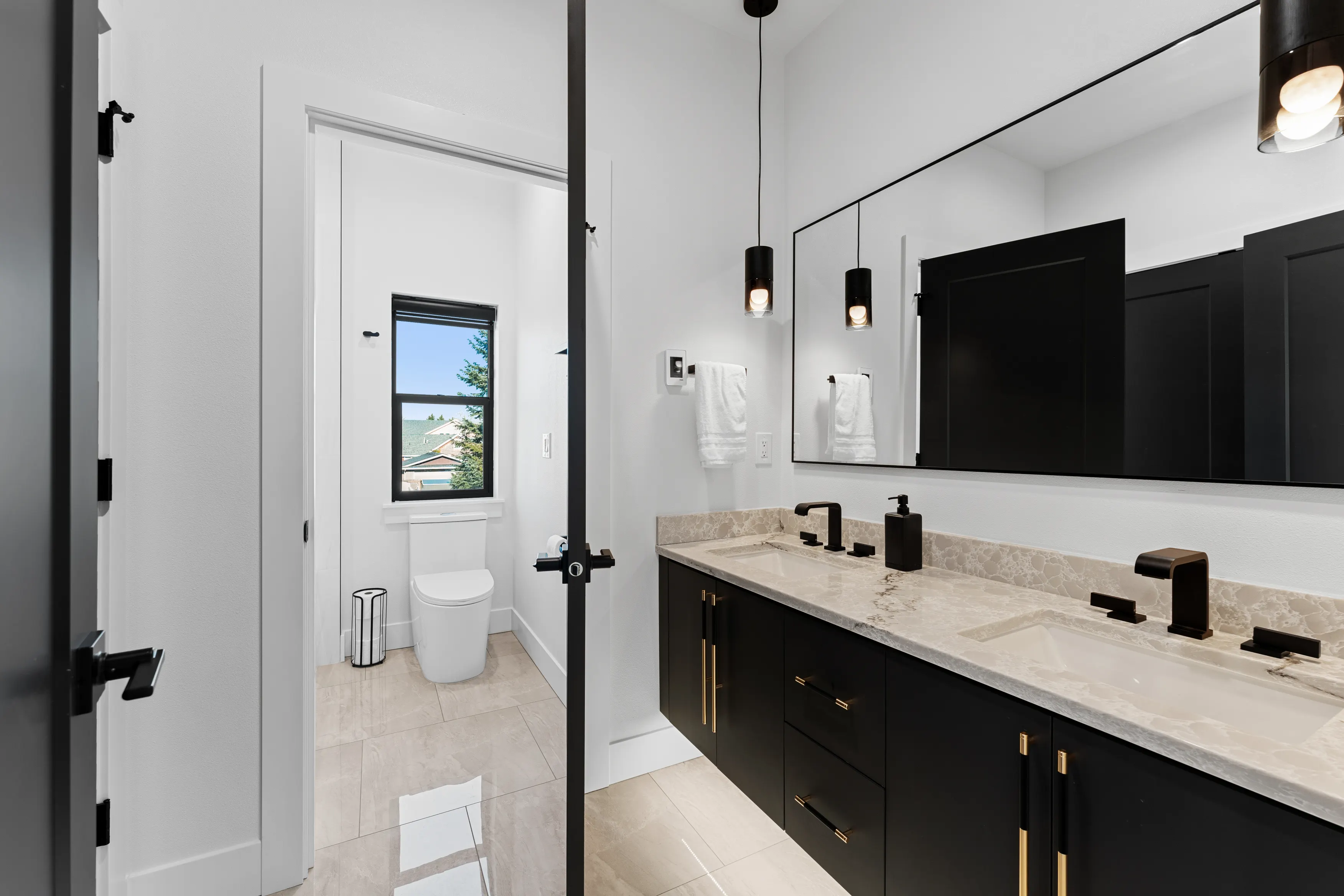 Modern custom bathroom in Issaquah with freestanding soaking tub, glass shower enclosure, and large window.