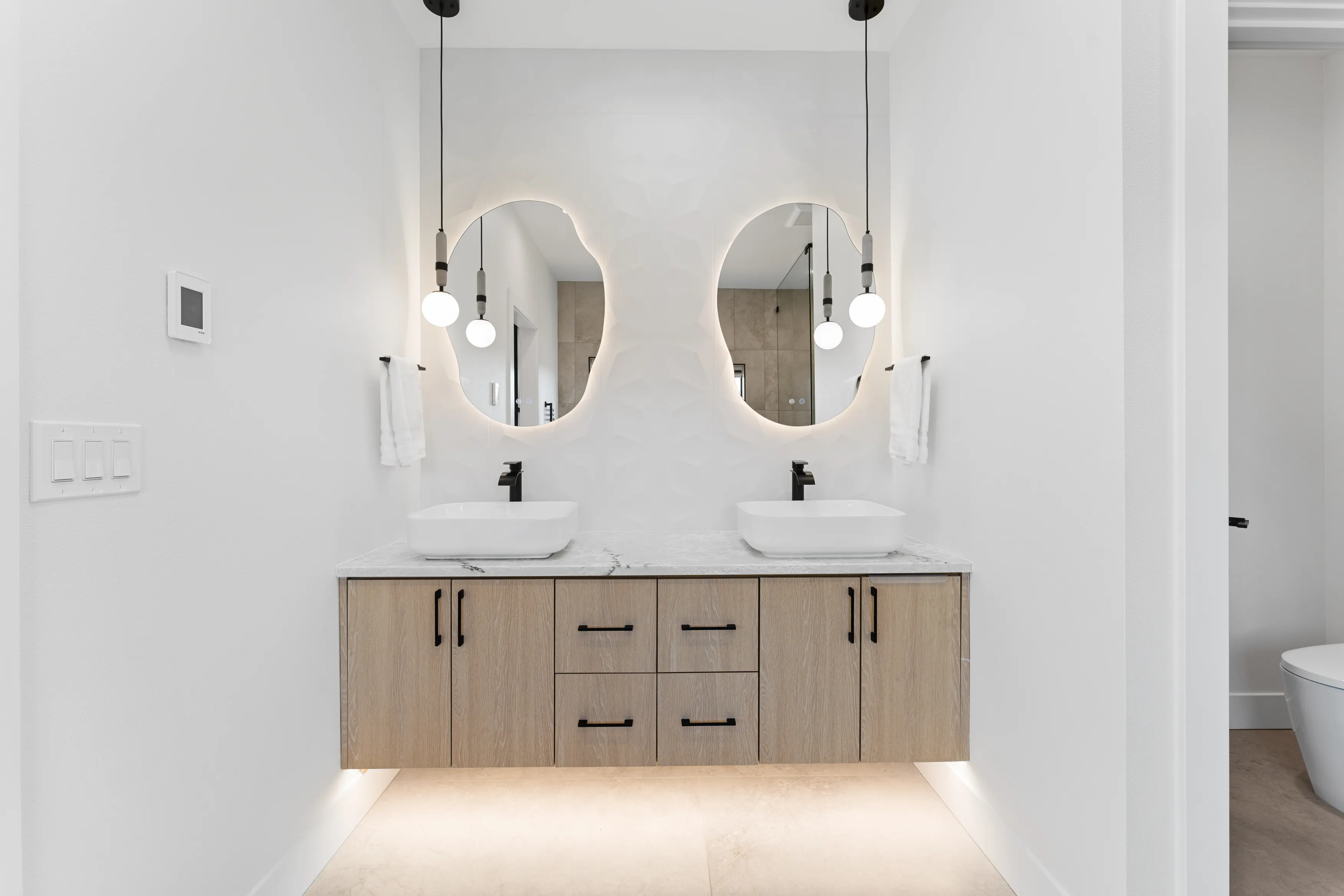 Modern custom kitchen design in Issaquah featuring a black island, wood cabinets, built-in appliances, and clean lines.