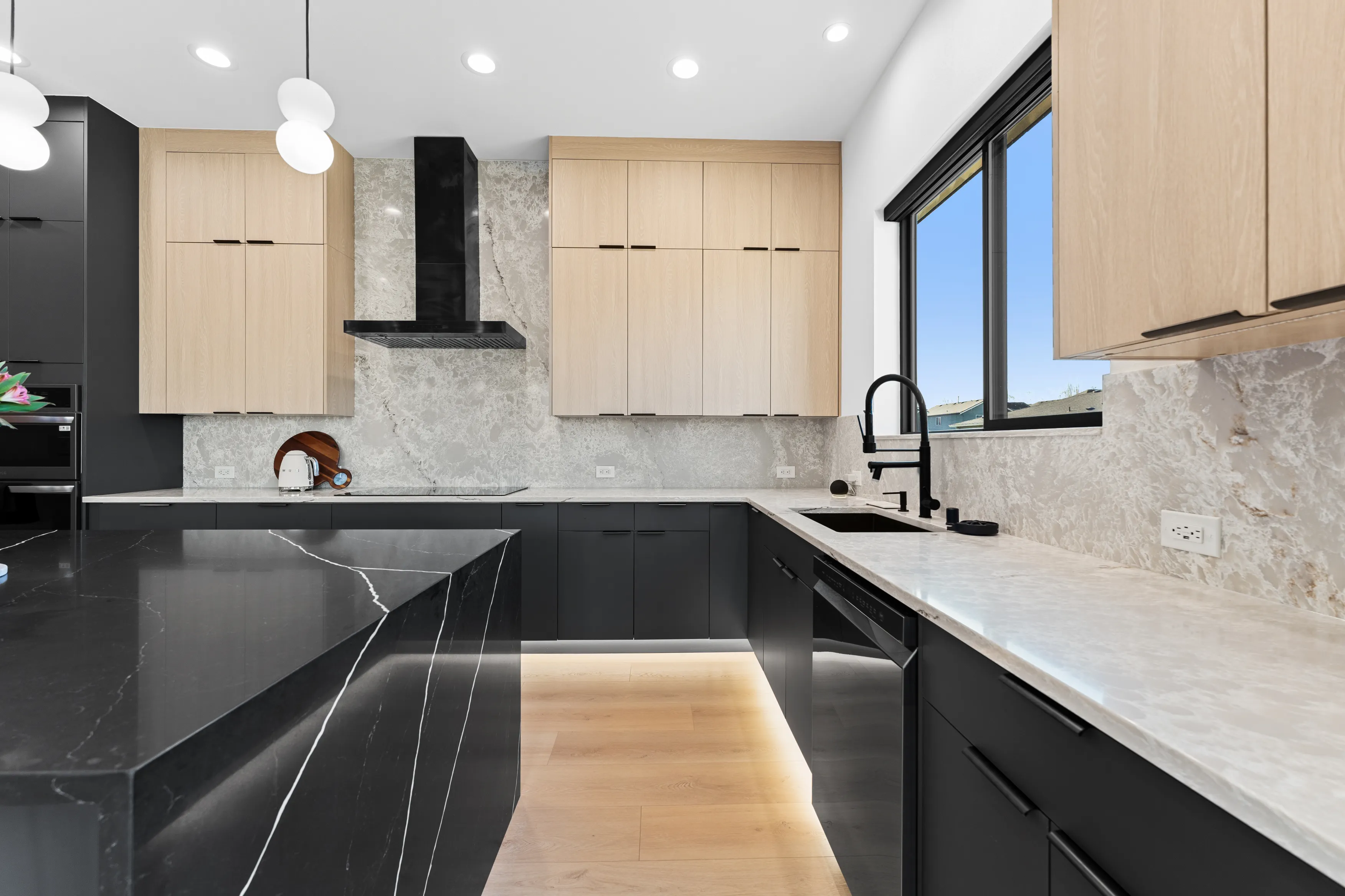 Open-concept kitchen in a custom Issaquah home with contemporary cabinetry, island seating, and modern lighting.