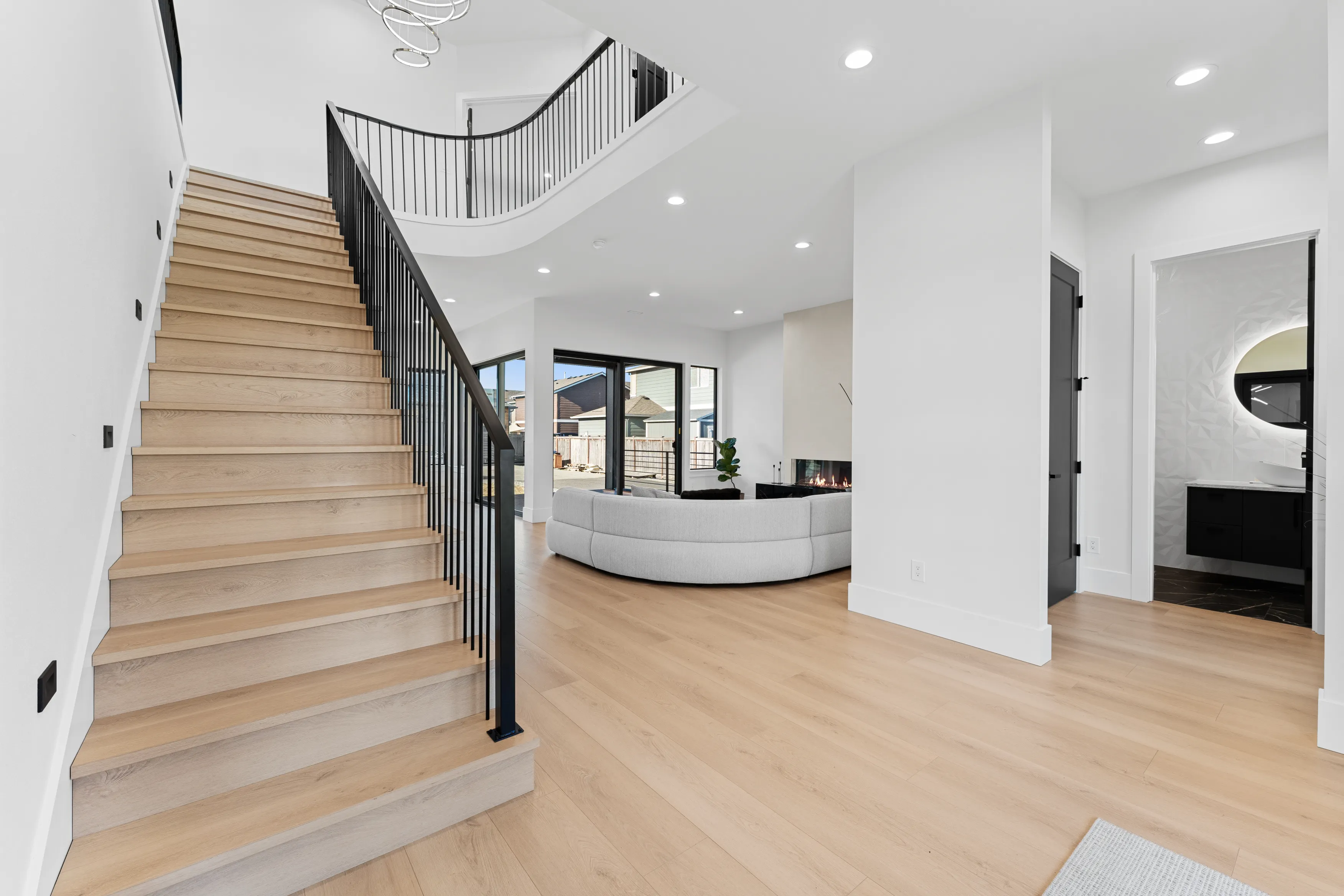 Open-concept living area in a custom Issaquah home featuring a modern staircase, natural wood flooring, and clean contemporary design