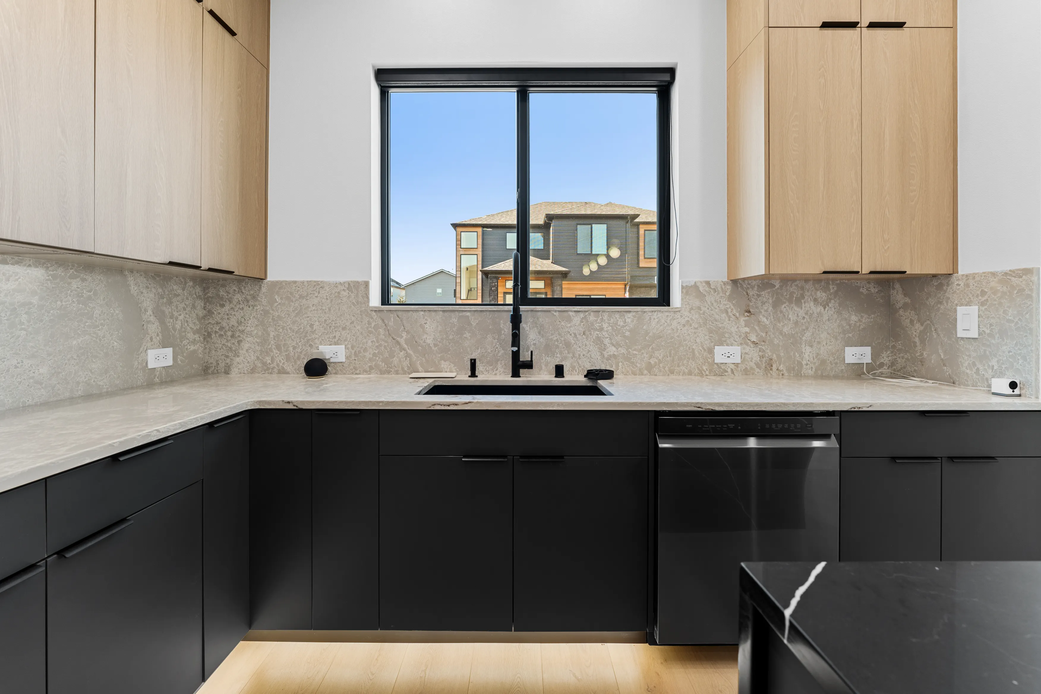 High-end custom kitchen in Issaquah showcasing black cabinetry, wood accents, large island, and minimalist design.