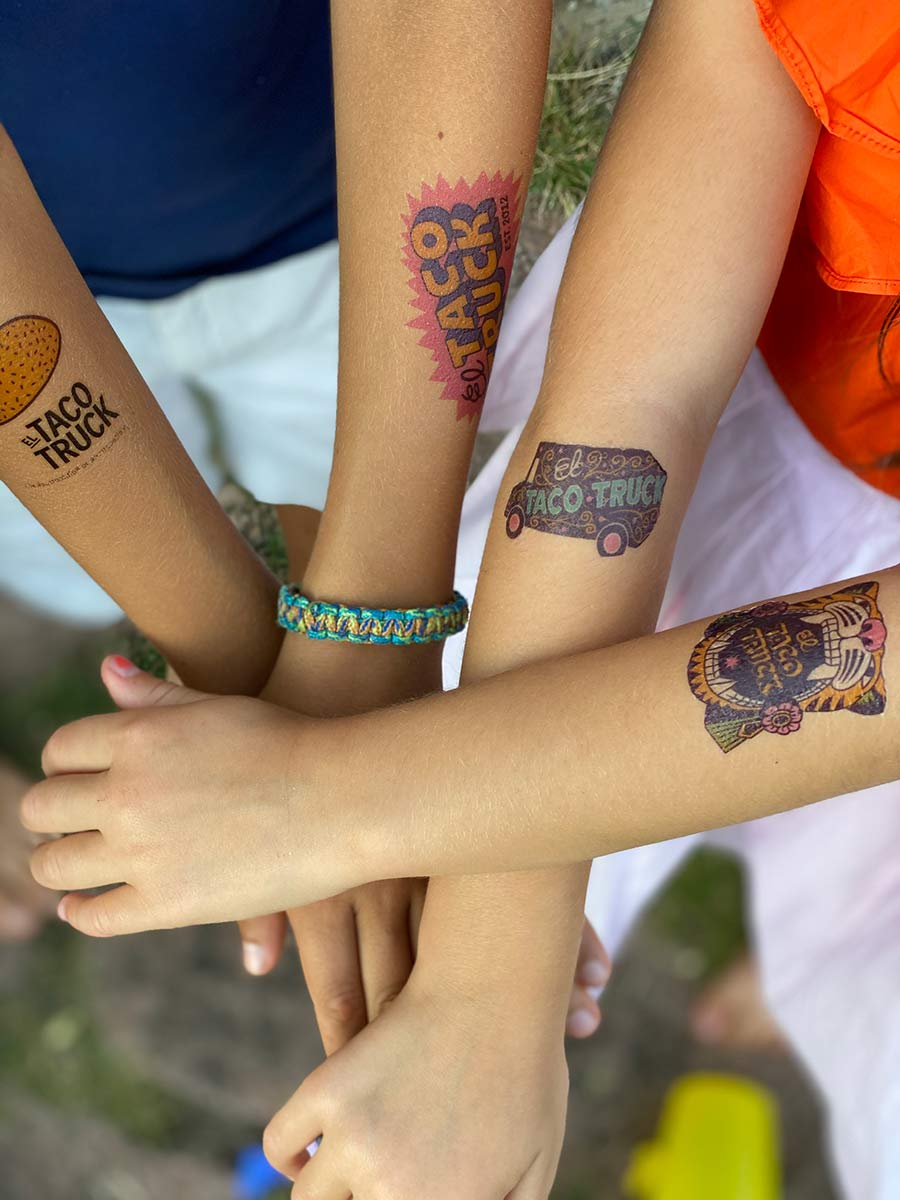 Armar med temporära tatueringar från el taco truck