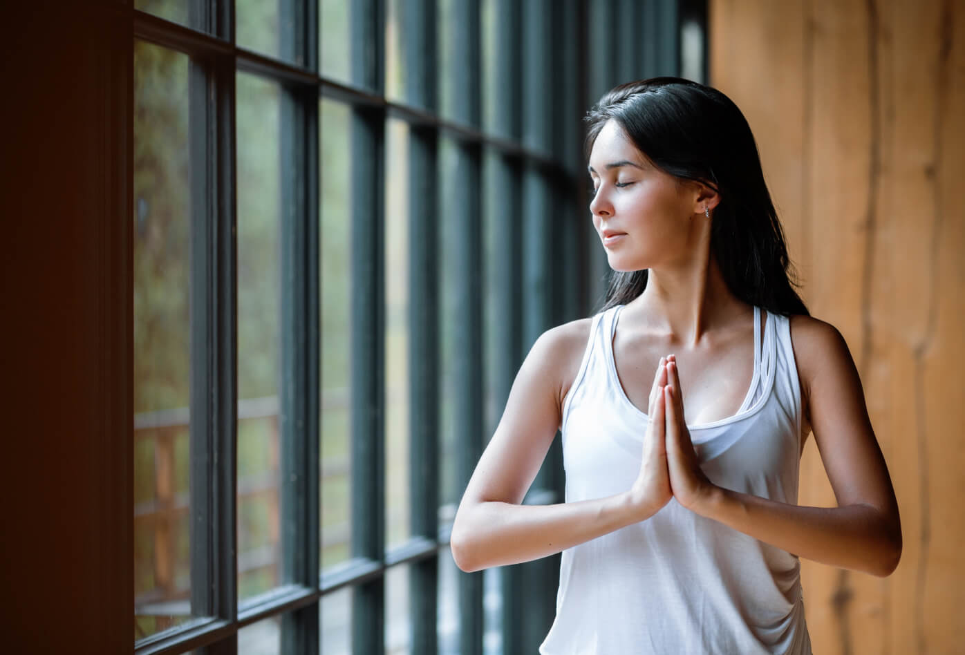 A woman meditating next in a spacious house