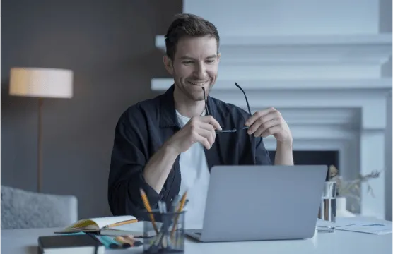 man smiling adn looking to a laptop