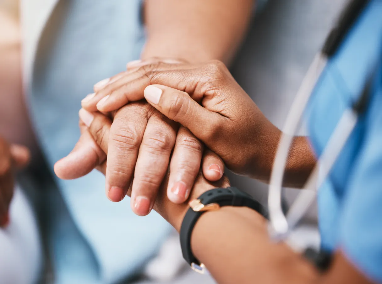 Healthcare professional holding someone's hand