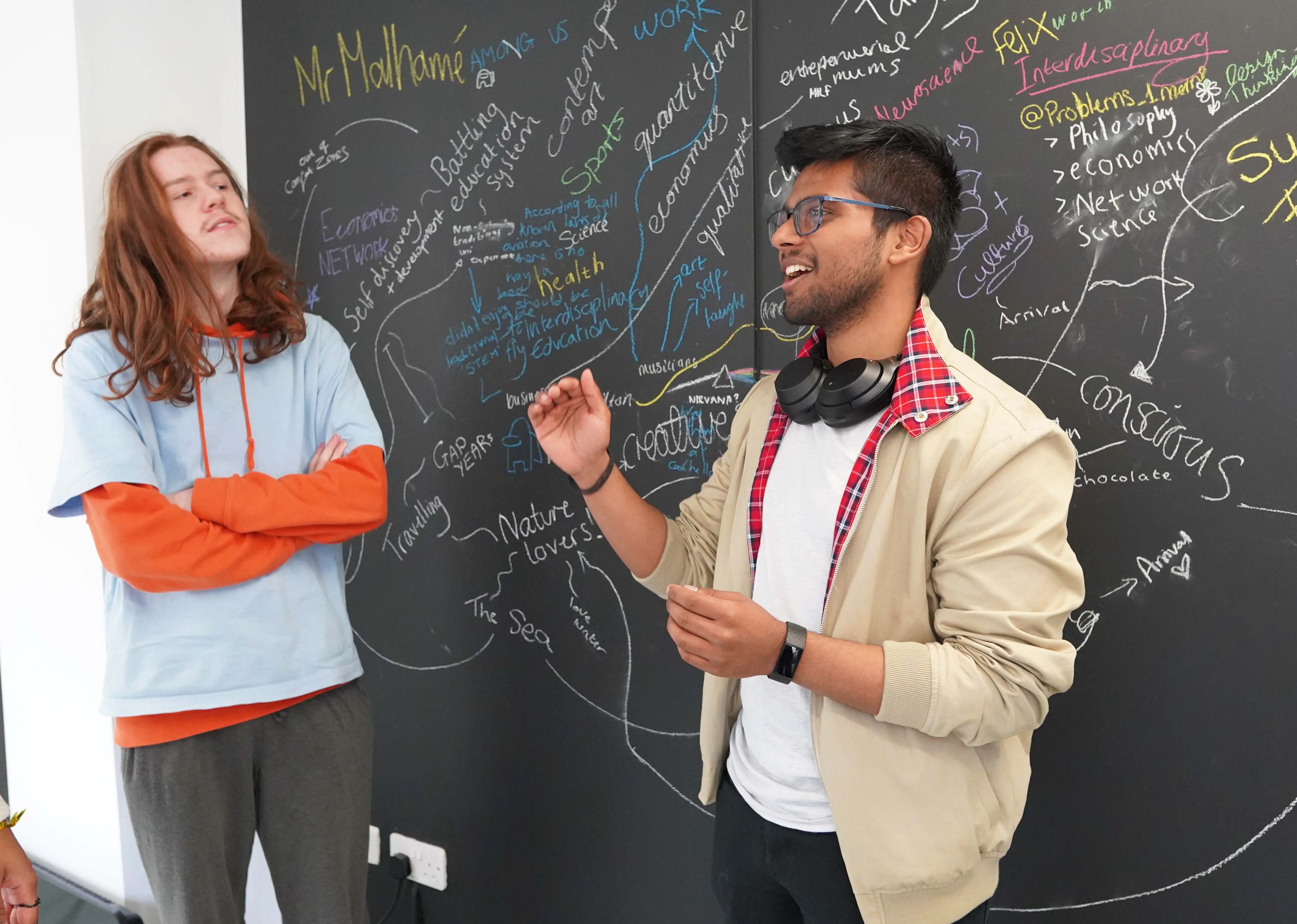 2 students in front of the board disscussing