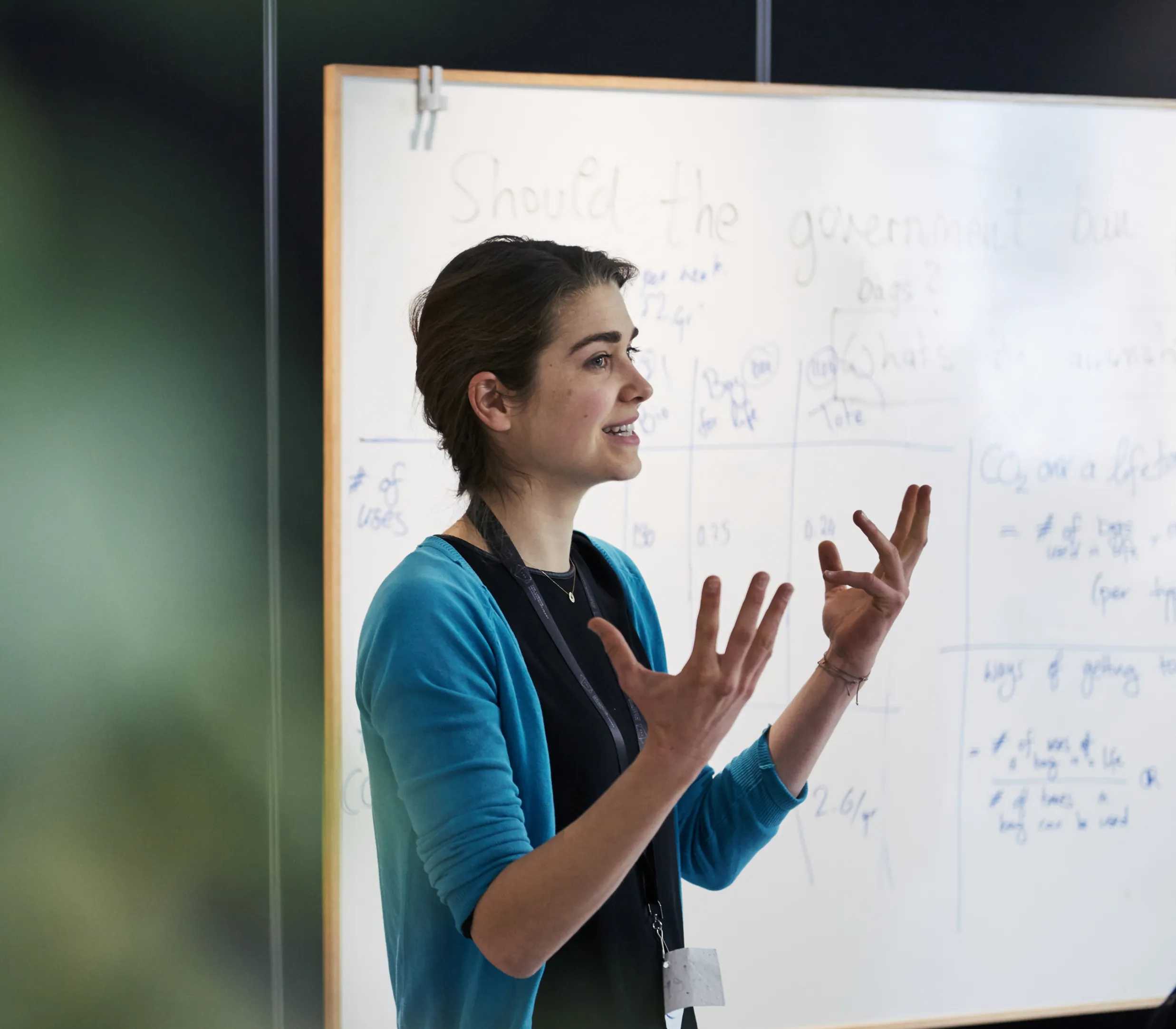 A woman presenting in front of a whiteboard during the 'Leading through Complexity' course, co-delivered with the London Interdisciplinary School