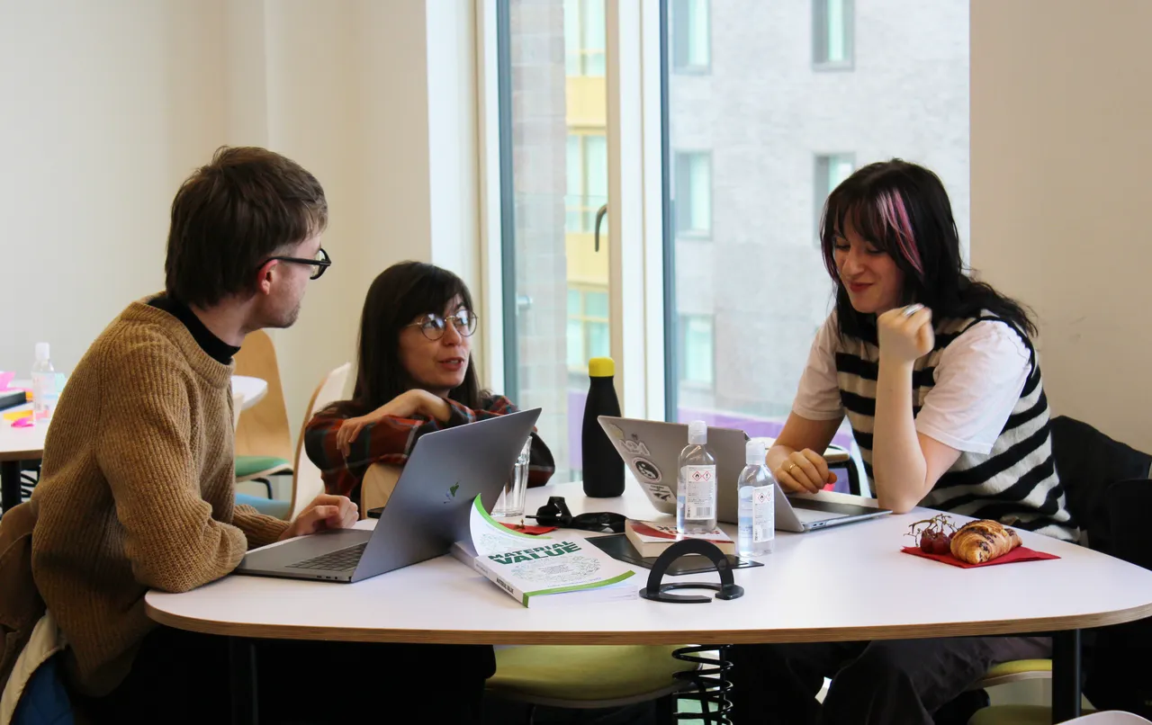 Students working together and discussing ideas in a contemporary academic setting.