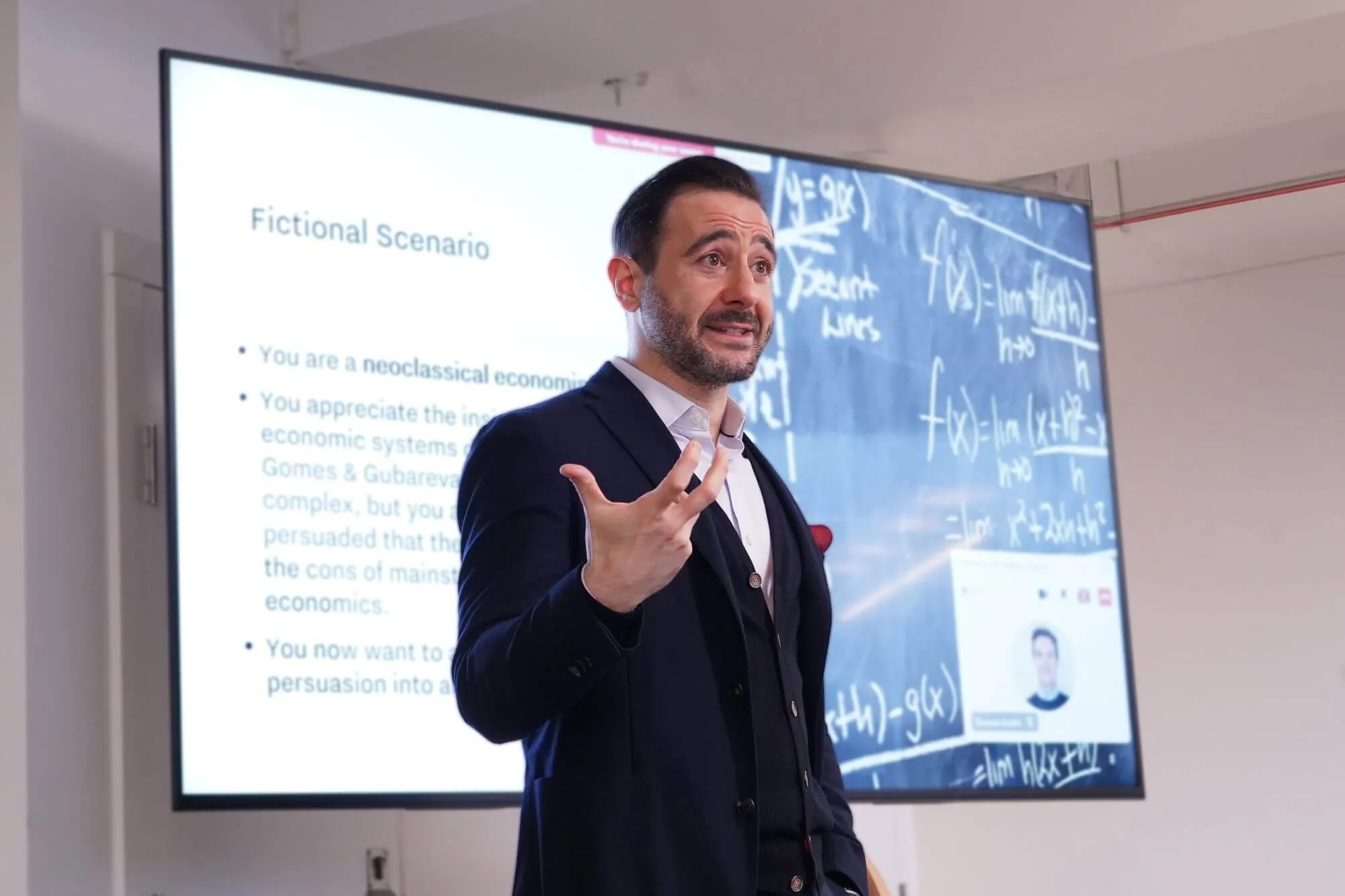 A LIS MBA professor delivers a lecture on economic systems, blending fictional scenarios with mathematical modeling on dual screens.