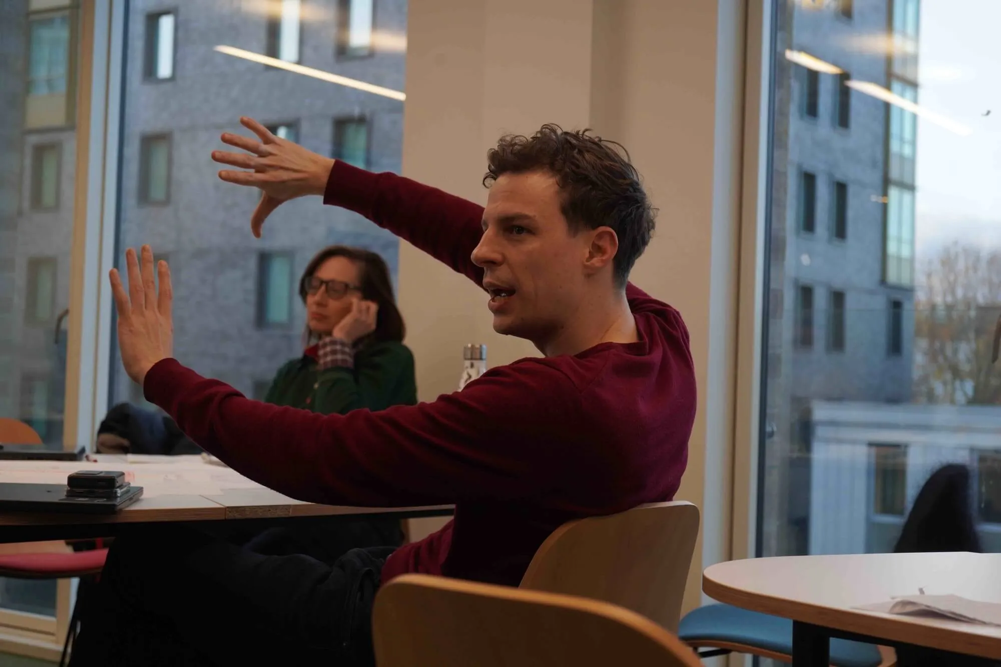 LIS MBA student presenting systems thinking insights during a seminar, gesturing toward conceptual frameworks in discussion.