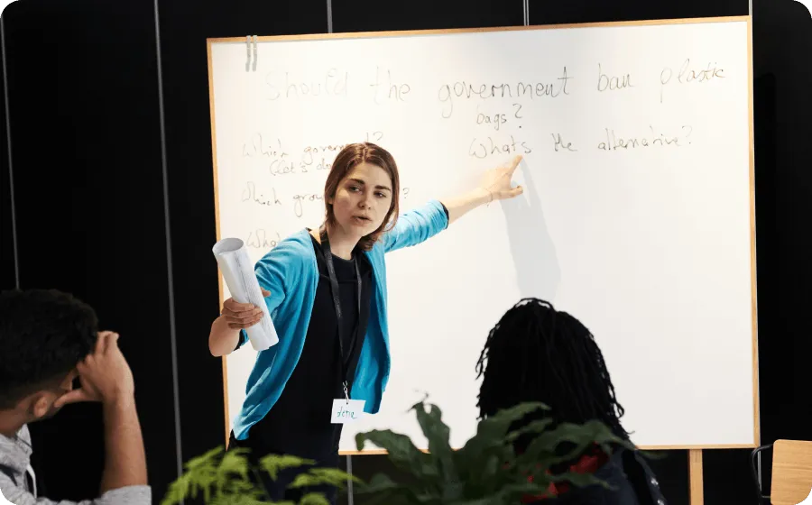 A LIS Proctor leading a discussion in front of a whiteboard