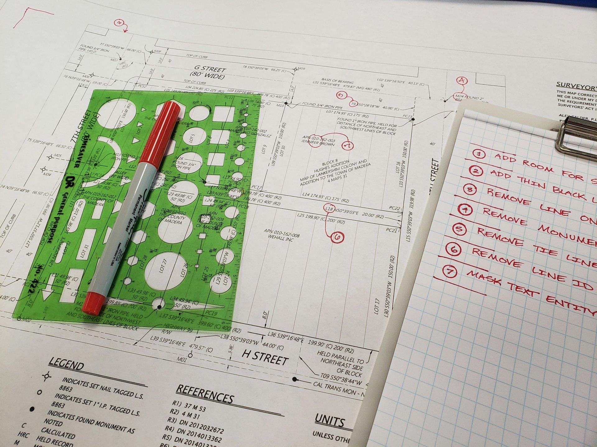 Red marker and a multifunctional geometric ruler on a white paper with printed notes
