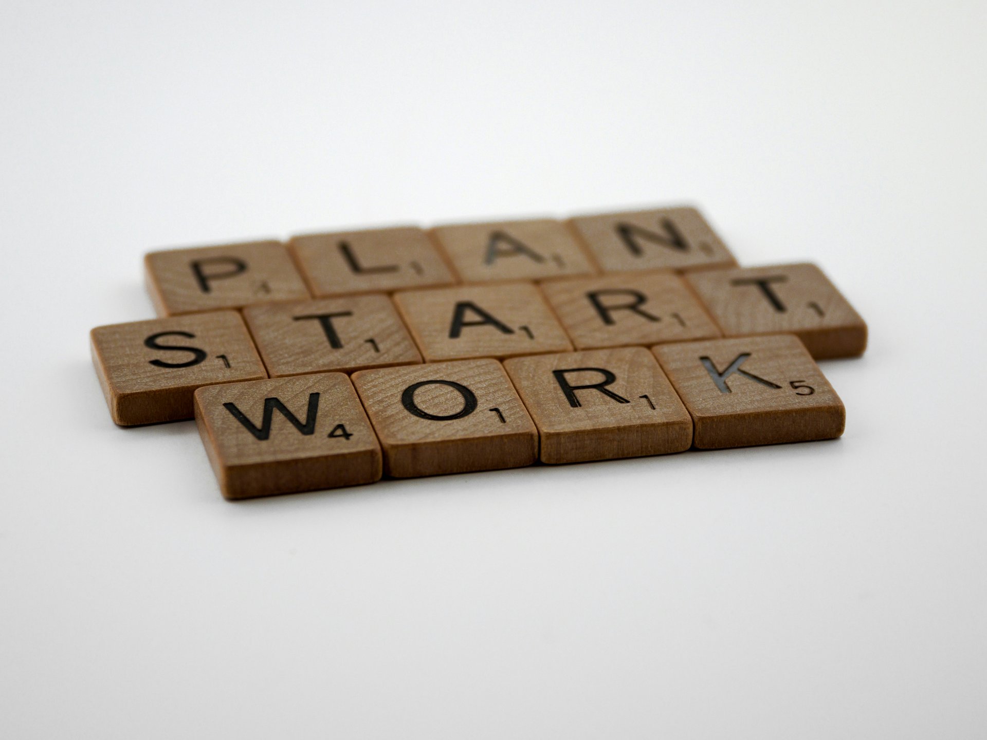 Wood carvings of letters that spell 'Plan', 'Start', and 'Work'