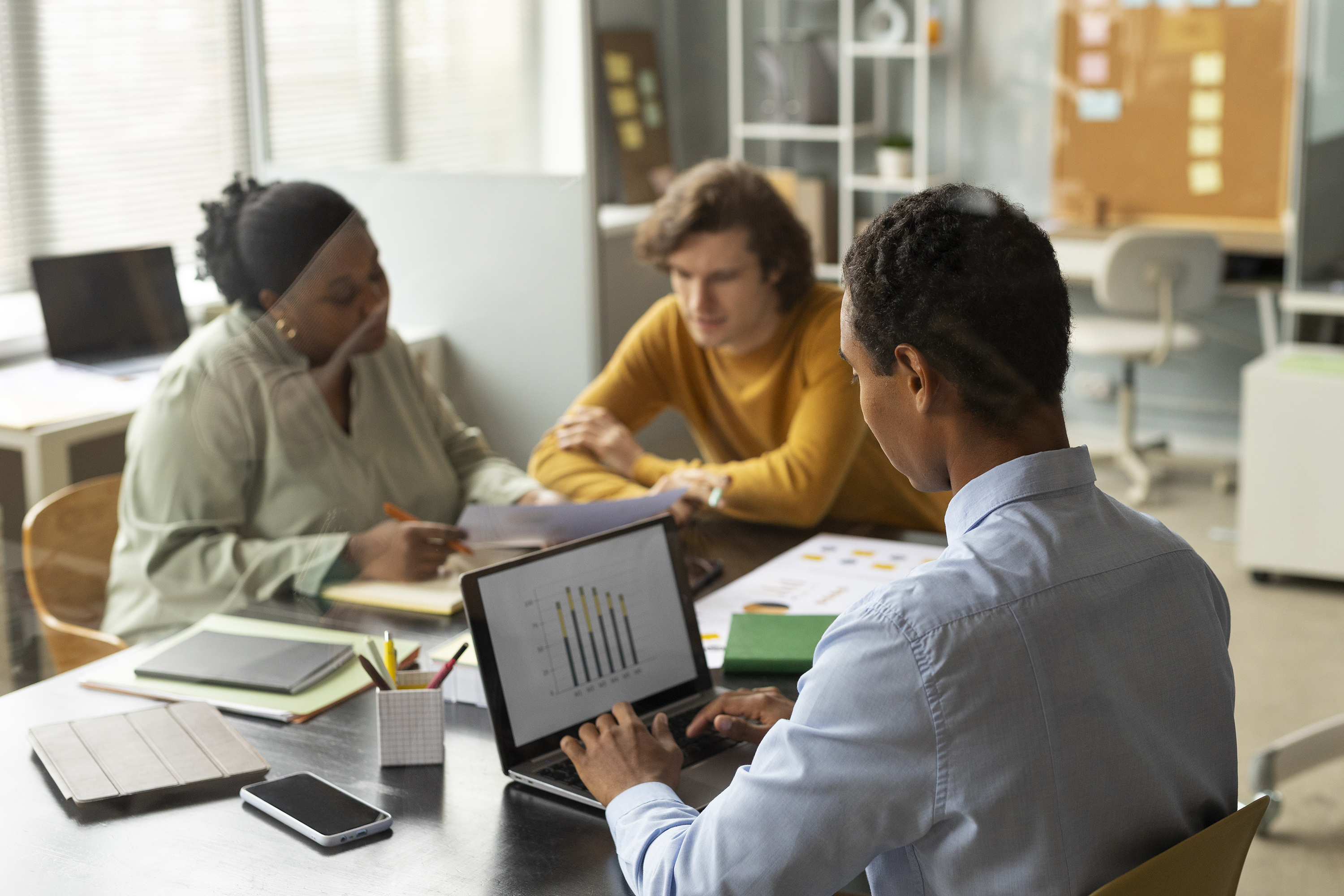 Workflow adoption for data dashboards: a team reviewing dashboard numbers together in a recurring operating meeting.