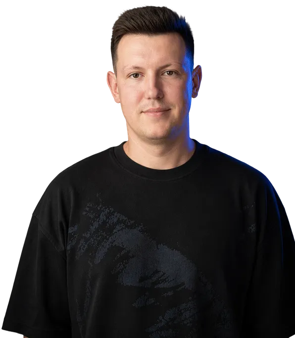 Man with short dark hair wearing a black t-shirt, facing forward with a neutral expression.