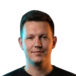 Portrait of a man with short dark hair against a black background.