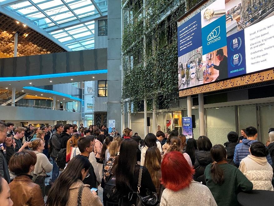 A group of people standing in a buildingAI-generated content may be incorrect.