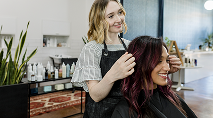 Stylist and client in a salon with retail products on display, representing Q2 online store product trends