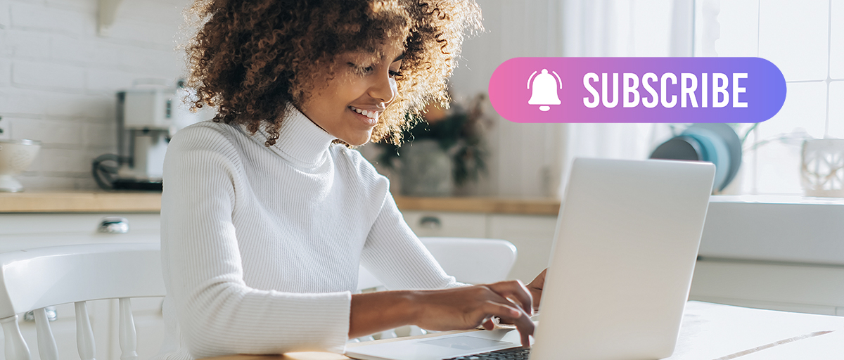 Smiling woman at a laptop with a Subscribe button, illustrating salon product subscriptions for recurring income