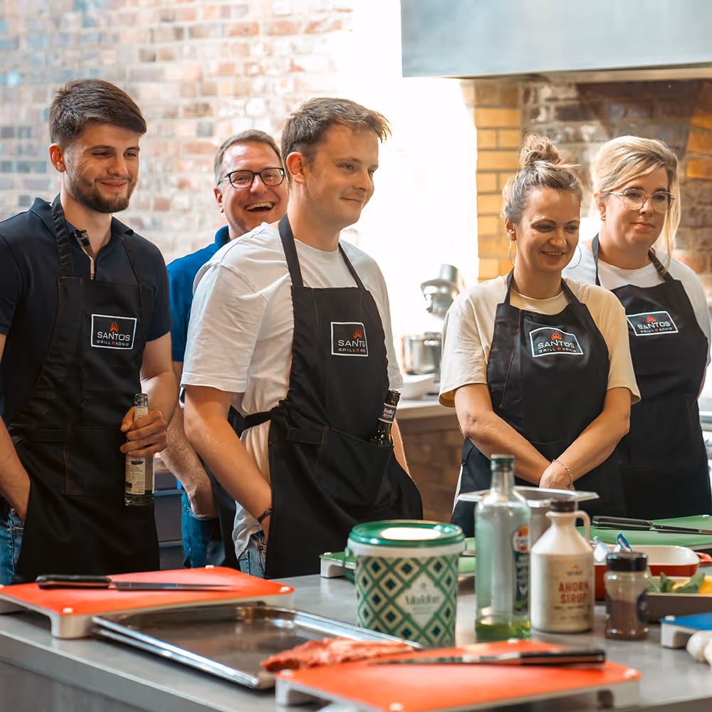 Team steht in einer Küche und hört gespannt zu