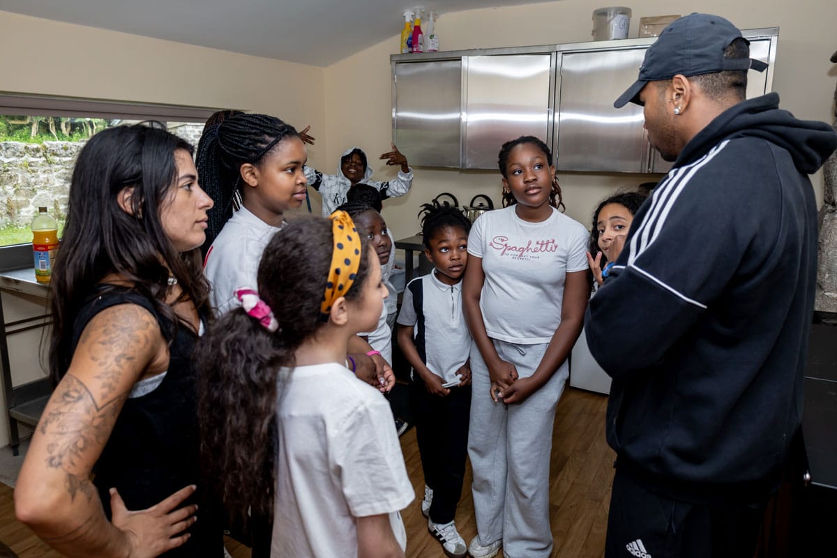 Dancer talks to children gathered around him