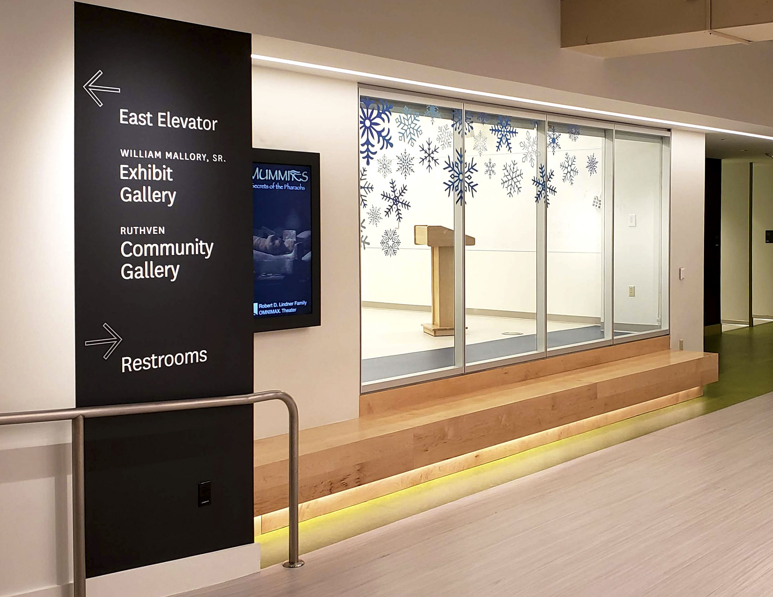 Cincinnati Museum Center interior floor-to-ceiling directional signage with white vinyl text and arrows on black, designed by Two Twelve