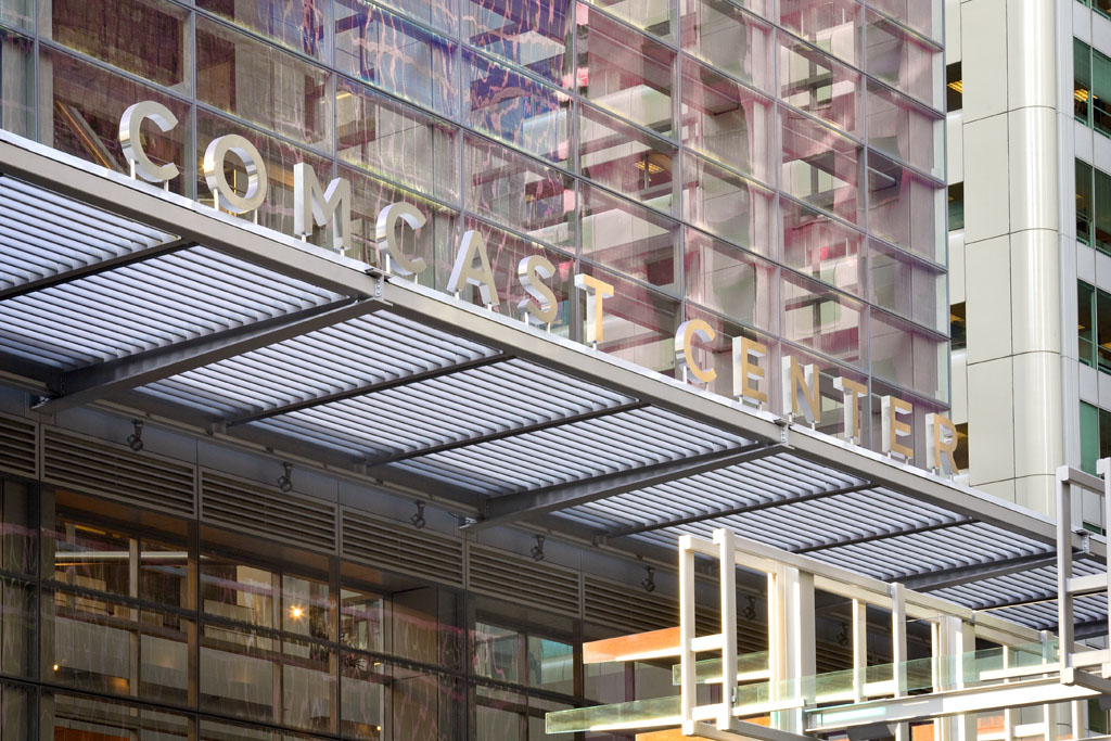 Comcast Center exterior identification sign mounted atop steel awning with dimensional stainless steel letters, designed by Two Twelve