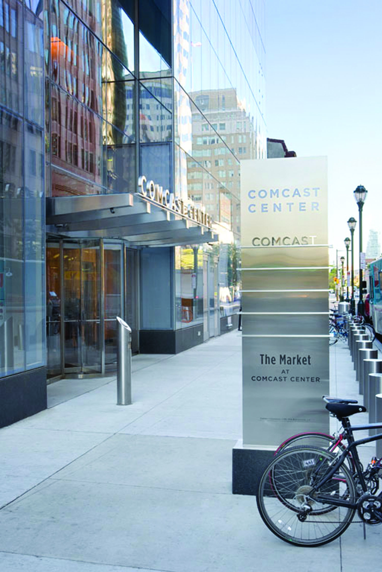 Comcast Center exterior ground-standing pedestrian identification and directory sign with stainless steel and stone, designed by Two Twelve