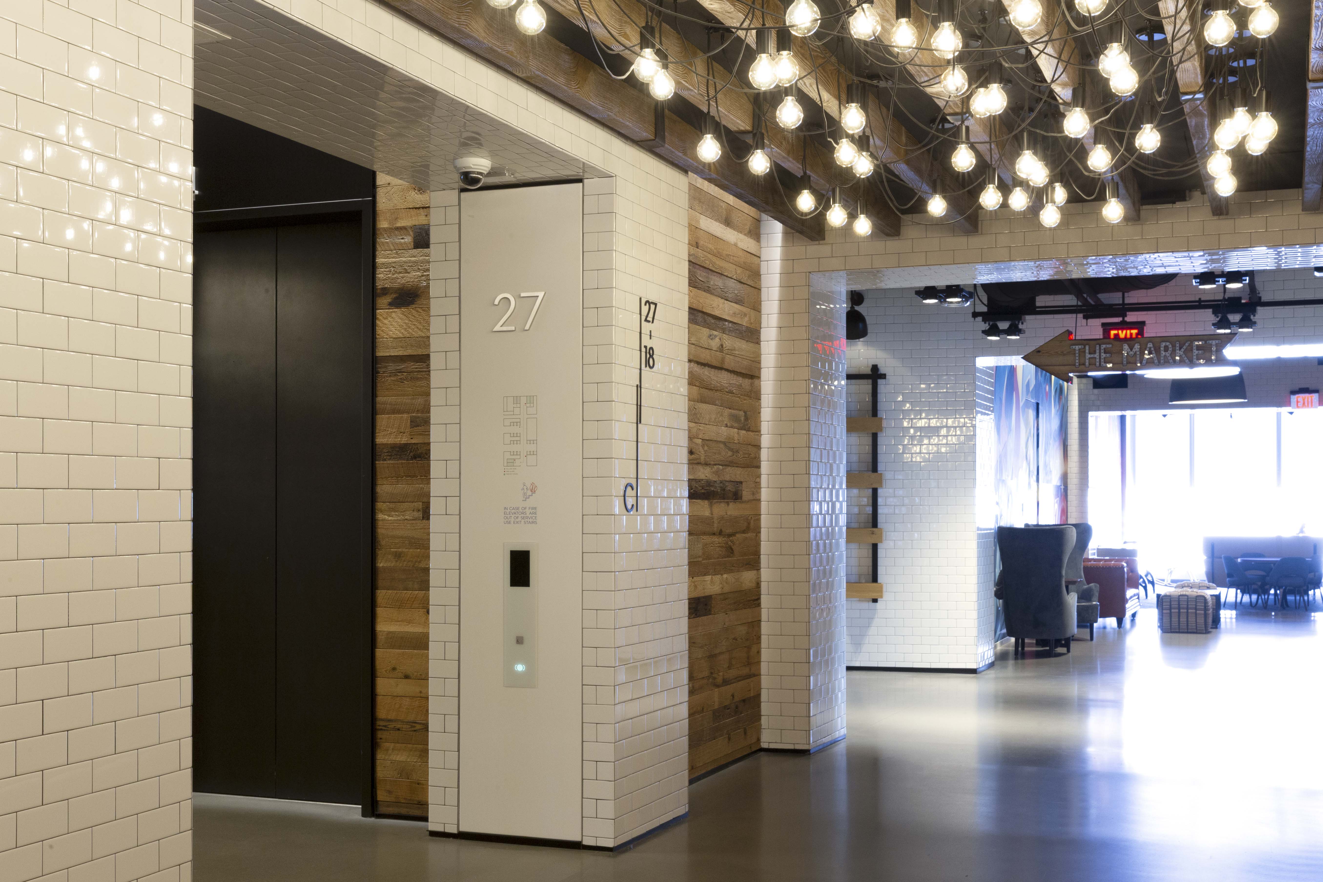 Comcast Innovation and Technology Center interior wall-mounted stainless steel dimensional level identification with emergency messaging, designed by Two Twelve