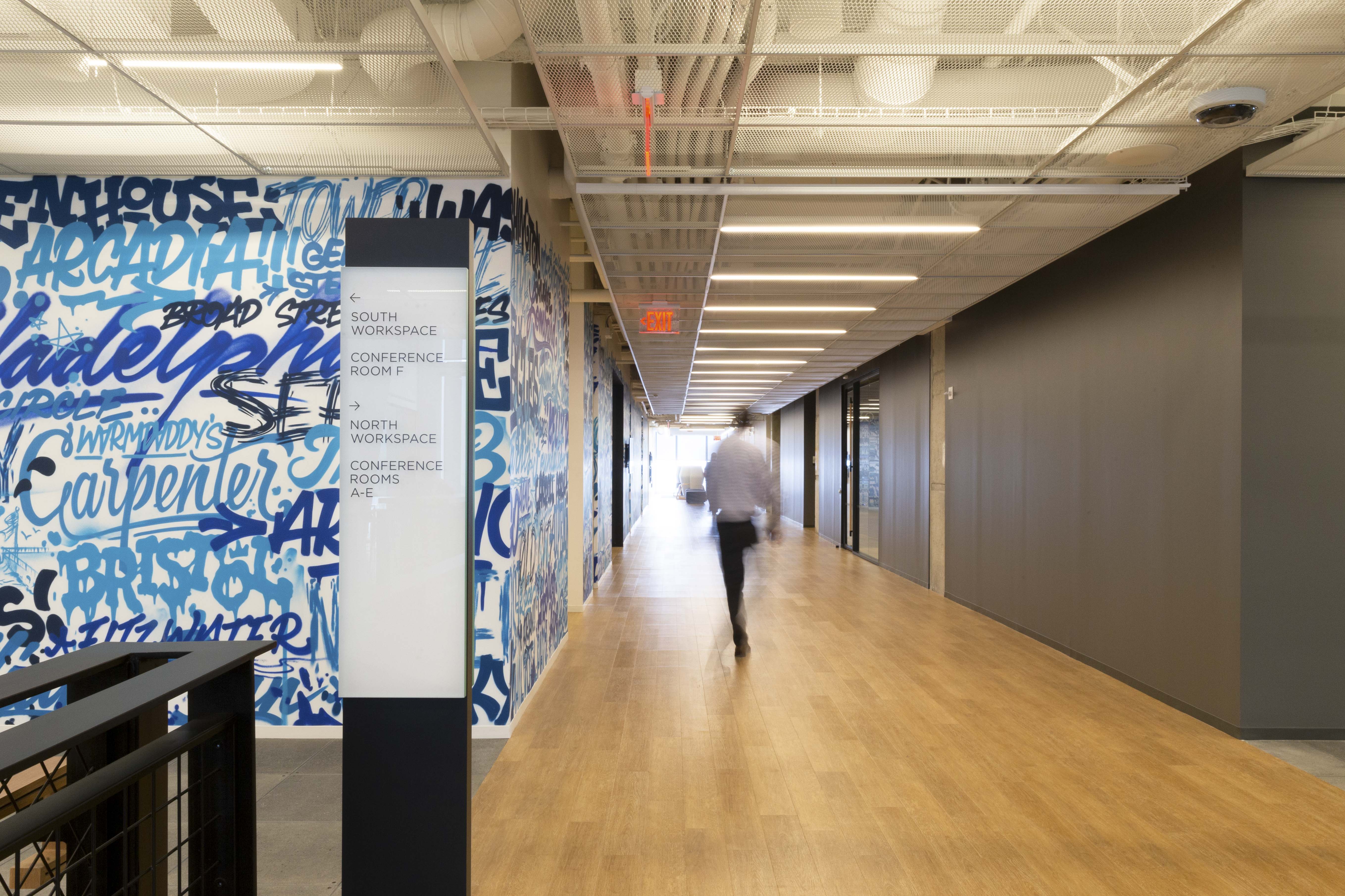 Comcast Innovation and Technology Center interior floor-standing directional sign with vinyl lettering on glass, designed by Two Twelve