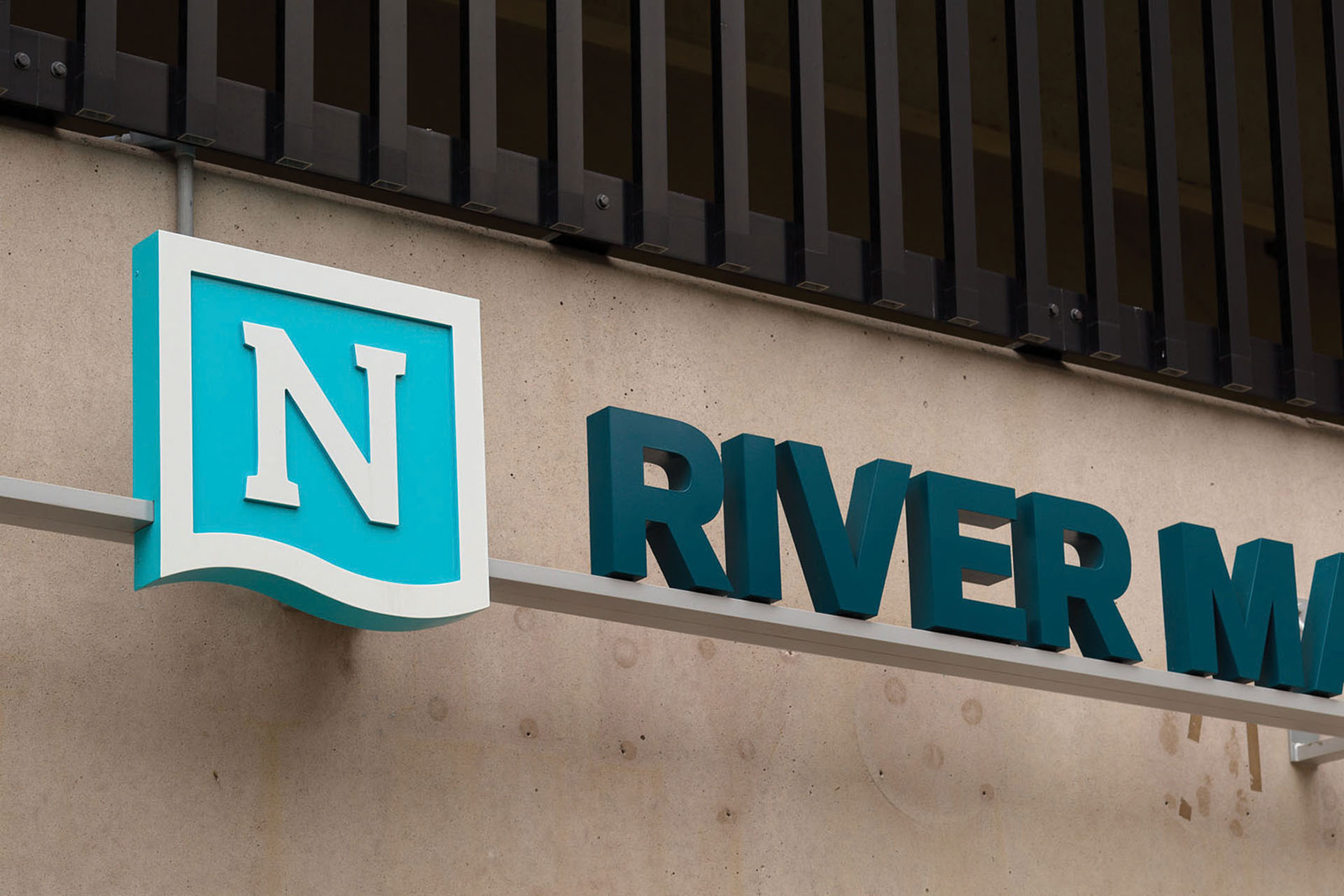 Community of Newport exterior wall-mounted identification sign for River Market Garage with dimensional lettering, designed by Two Twelve