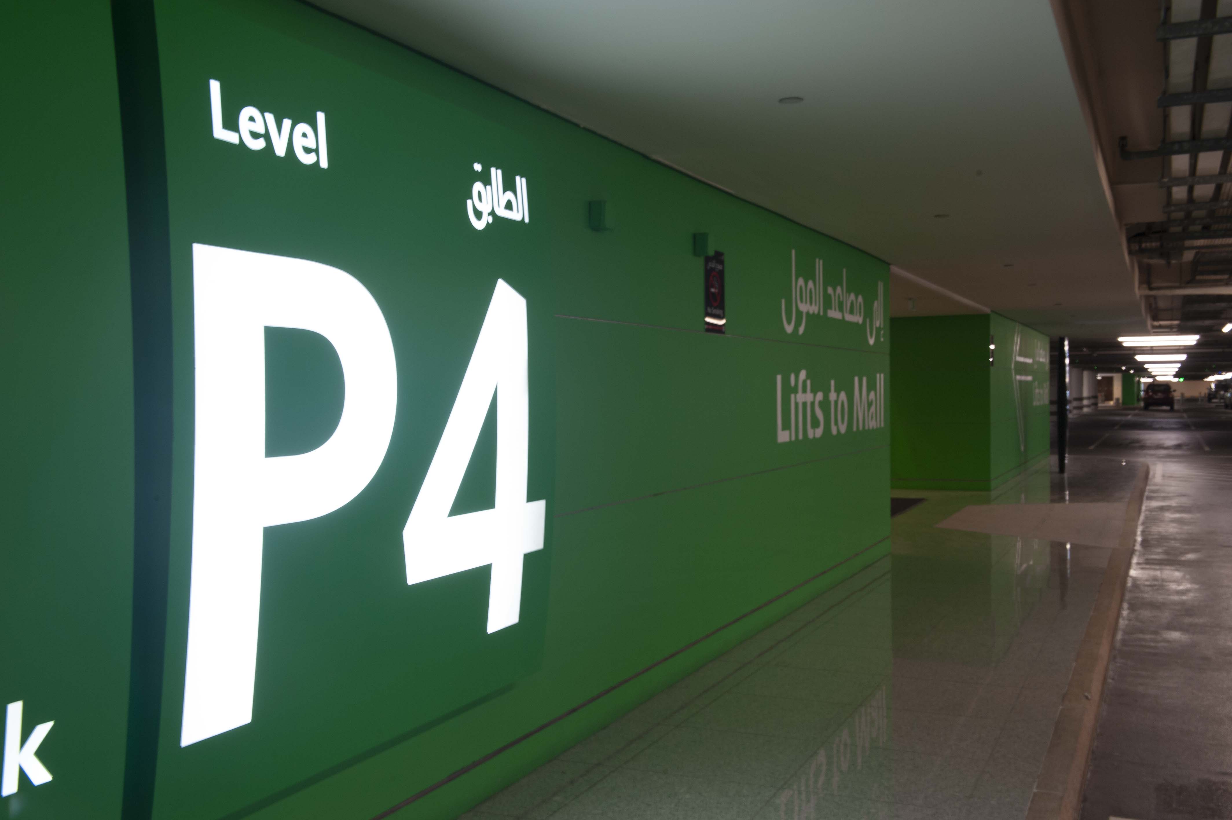 Dubai Mall interior wall-mounted parking garage level identification sign with illuminated green panel, designed by Two Twelve