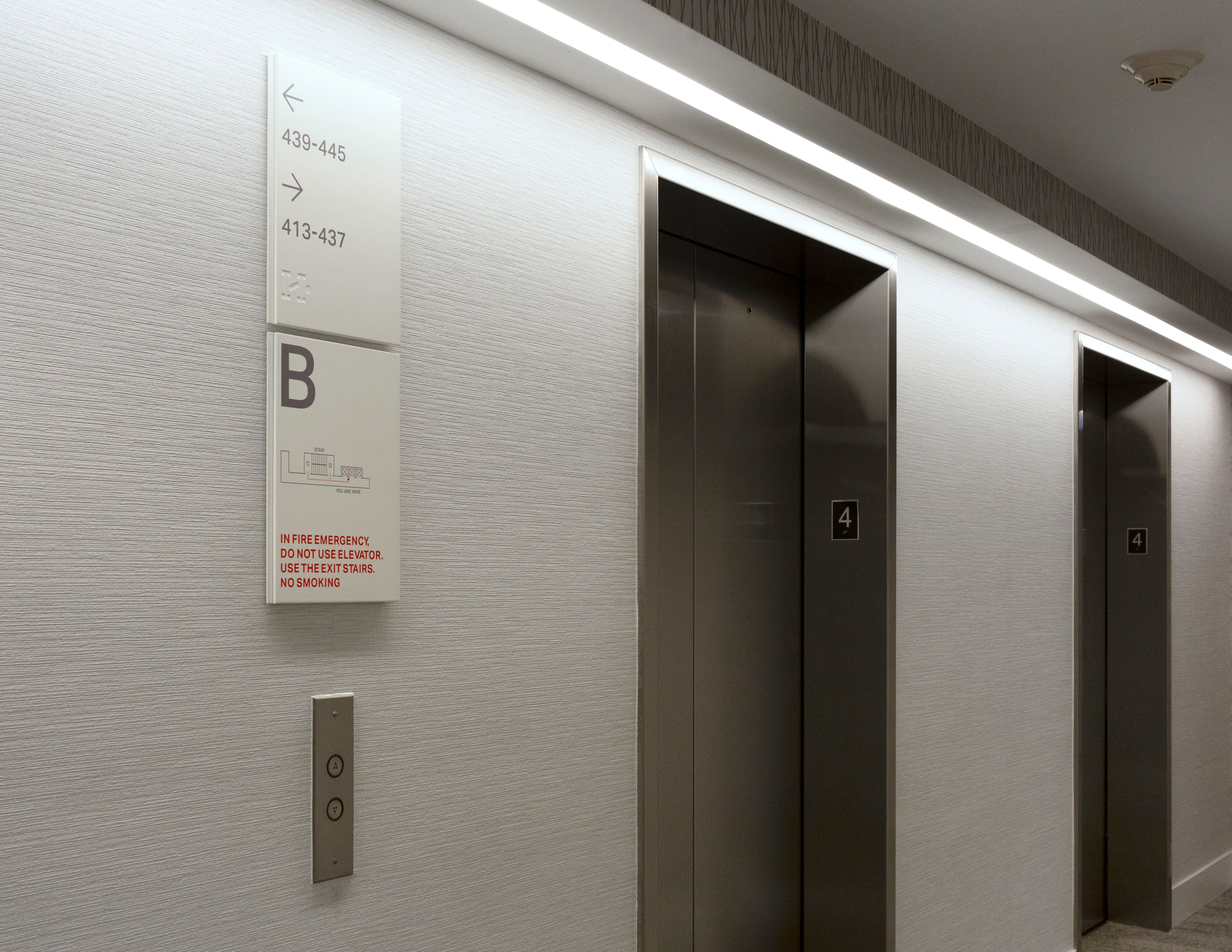 Halletts Point interior apartment directional sign and elevator emergency signage with fire evacuation map, designed by Two Twelve