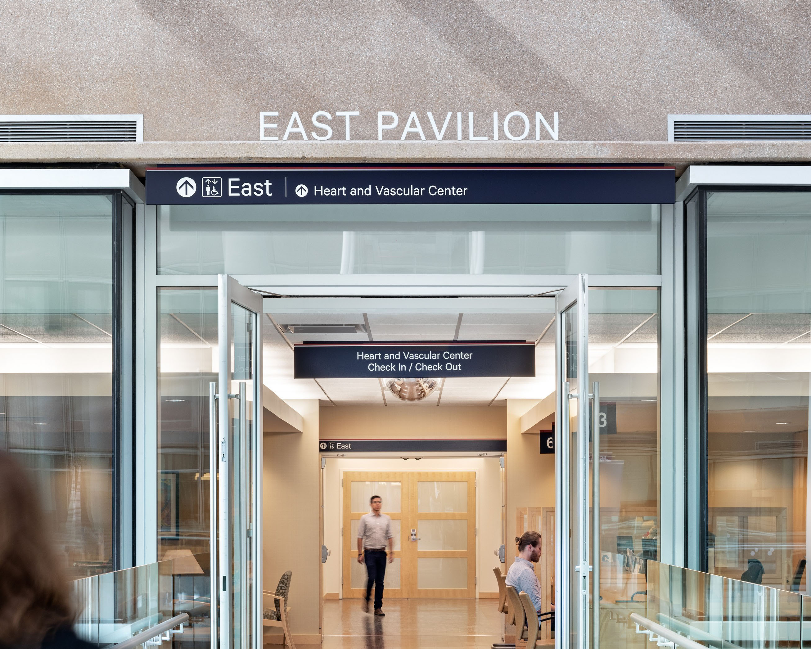 Penn Medicine pavilion identification with overhead directional signs and check-in information, designed by Two Twelve
